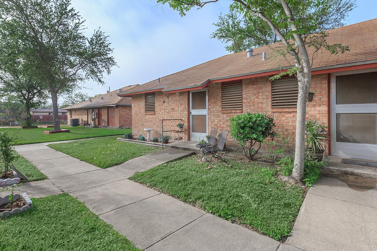 a large brick building with grass in front of a house