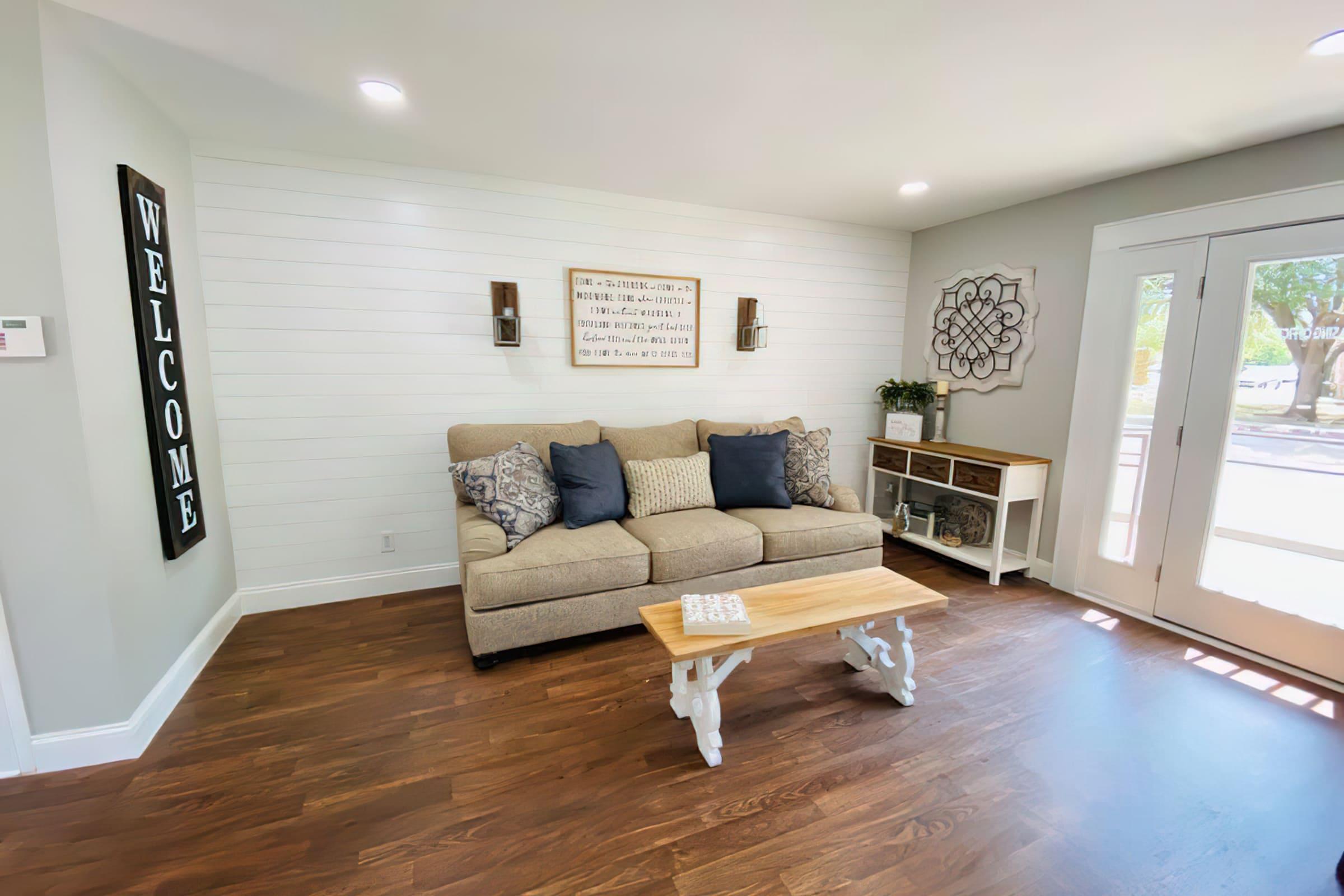 a living room filled with furniture on top of a hard wood floor