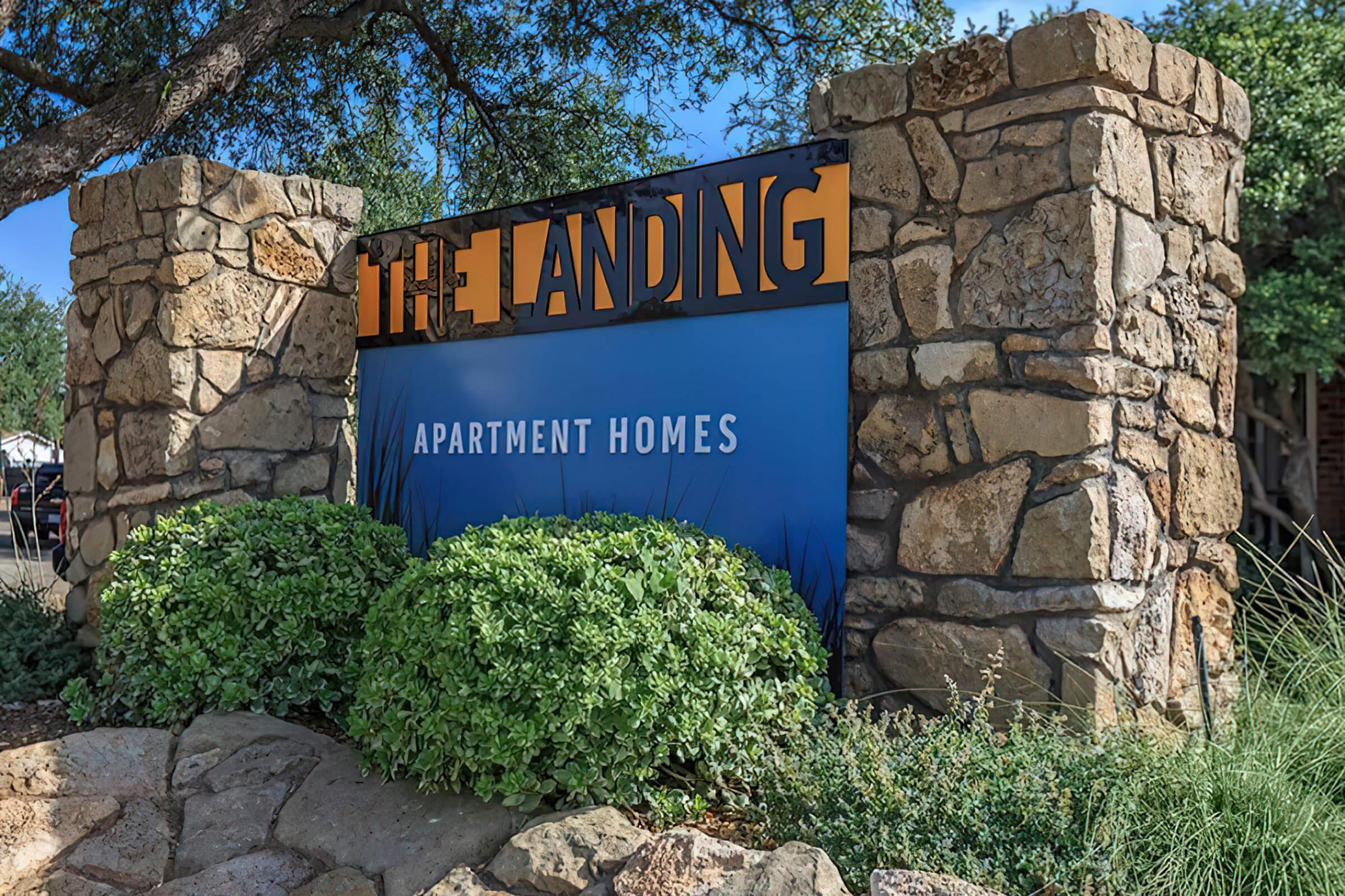 a sign in front of a large rock