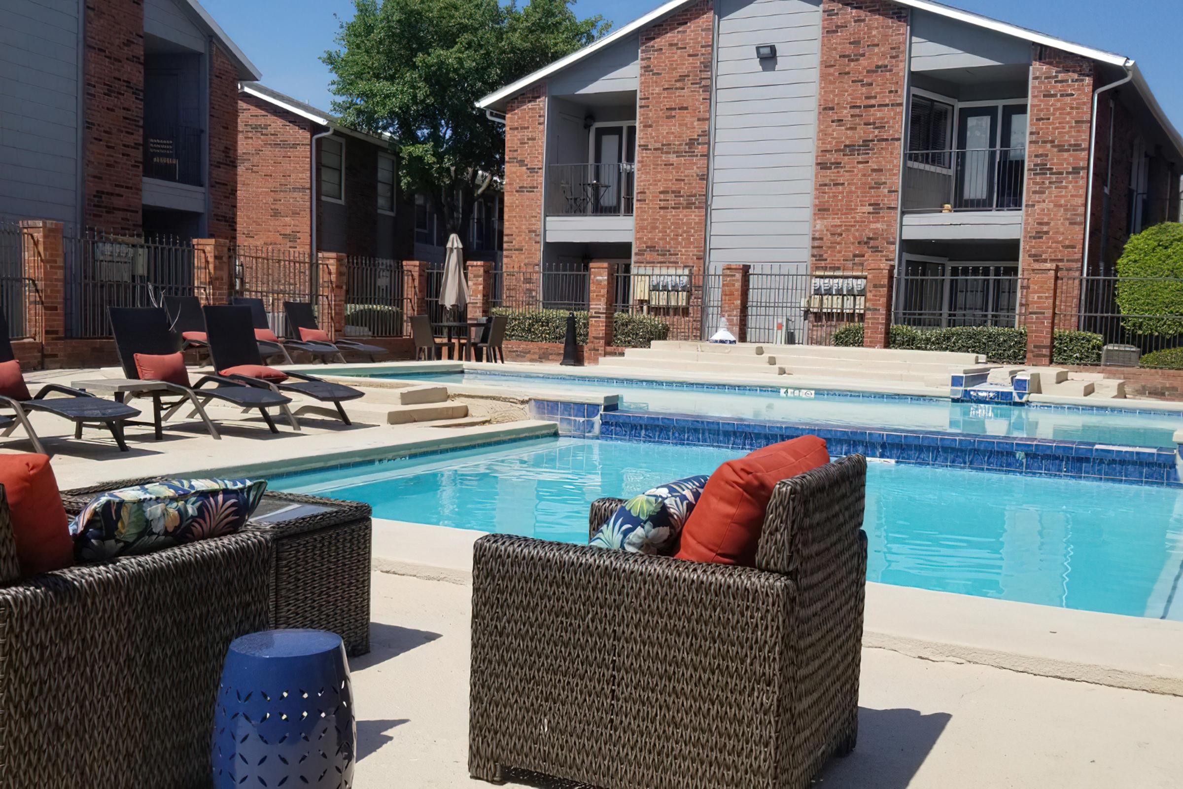 a house with a pool in front of a brick building