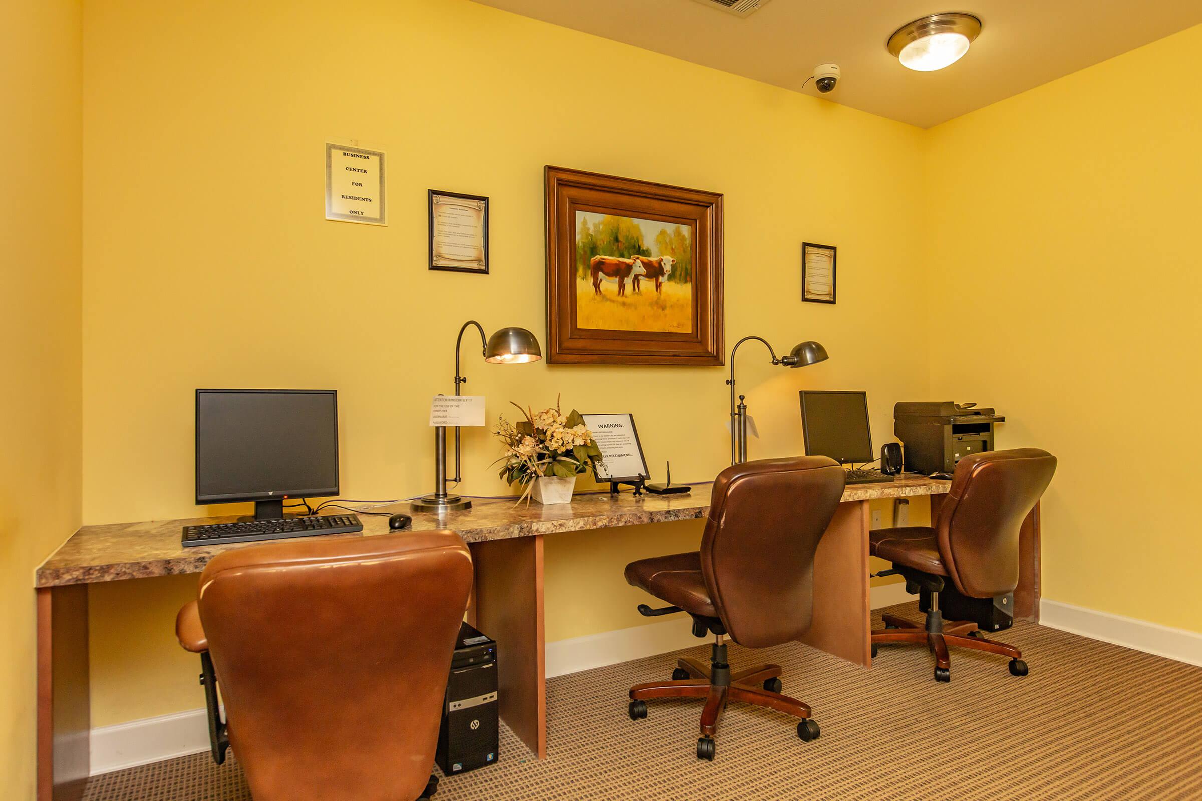 a living area with a desk and chair in a room