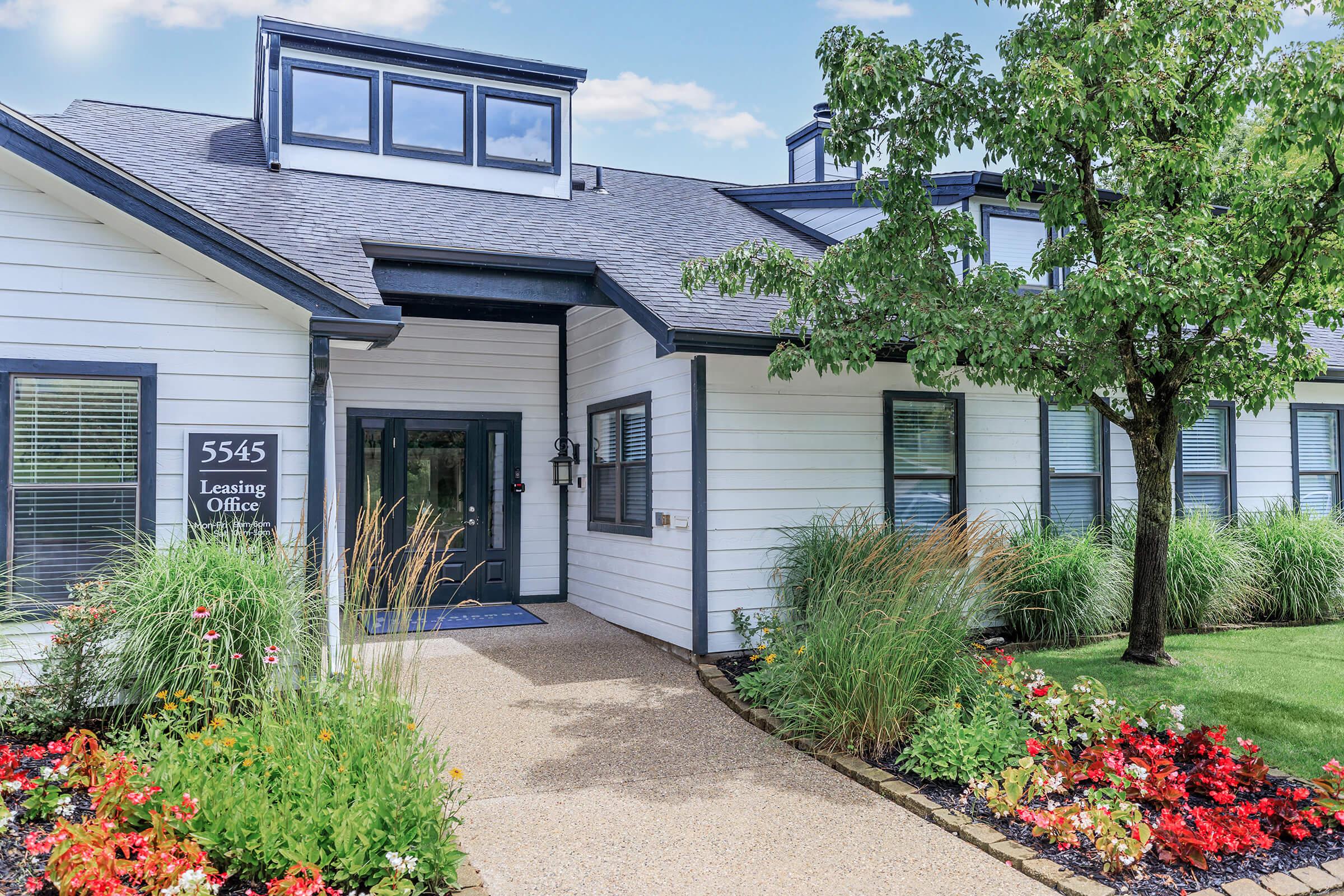 a close up of a flower garden in front of a house