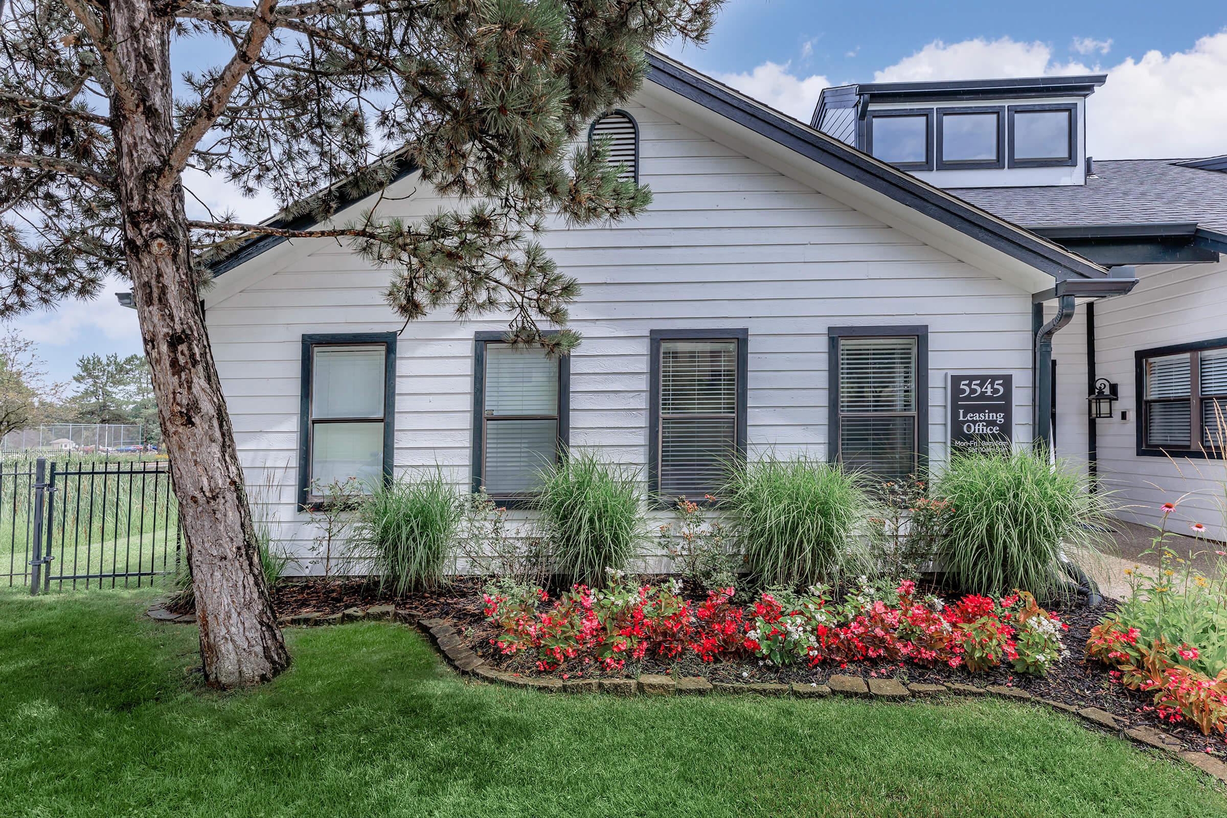 a close up of a flower garden in front of a house