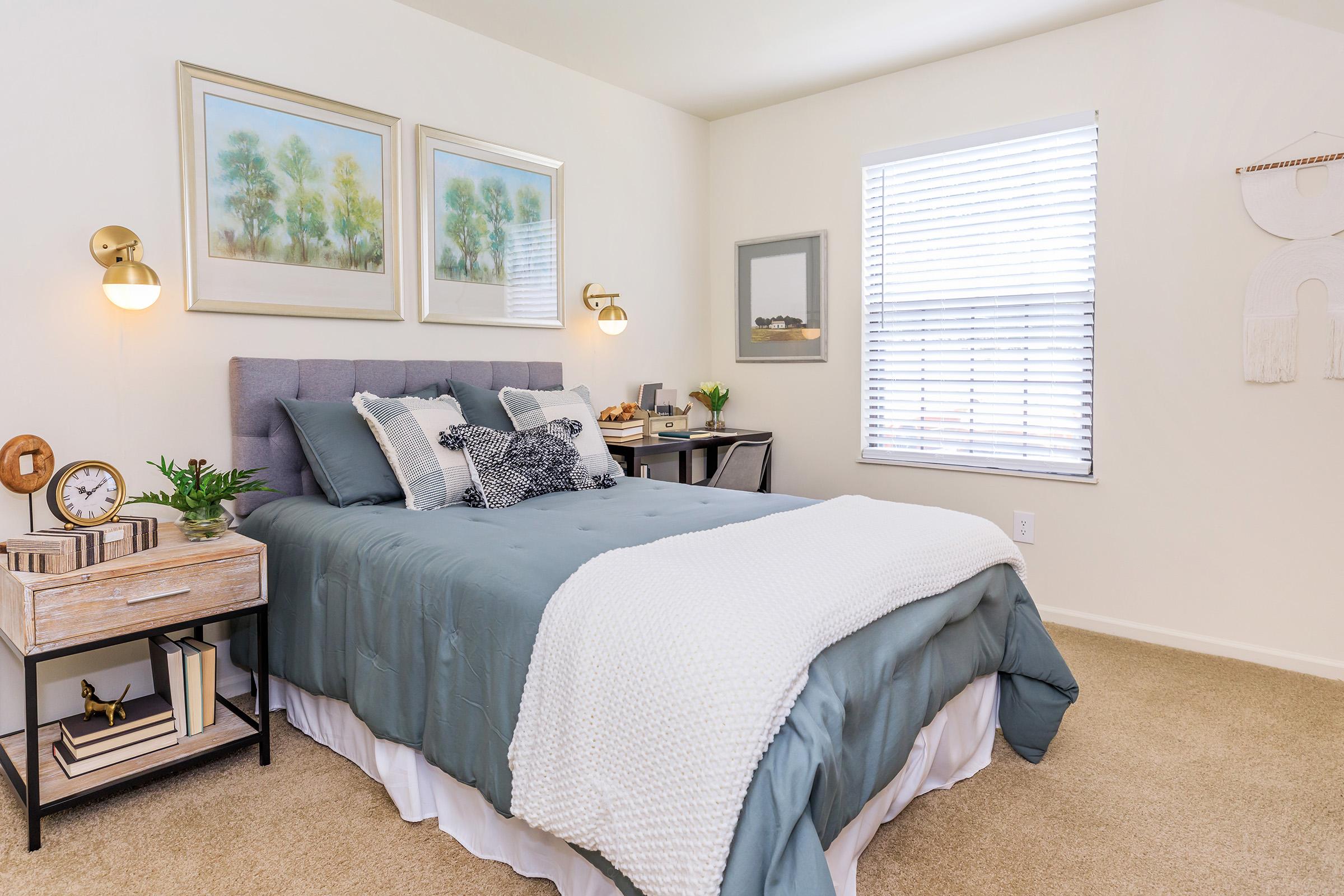 a bedroom with a bed and desk in a room