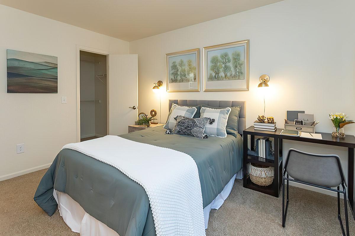 a bedroom with a bed and desk in a hotel room
