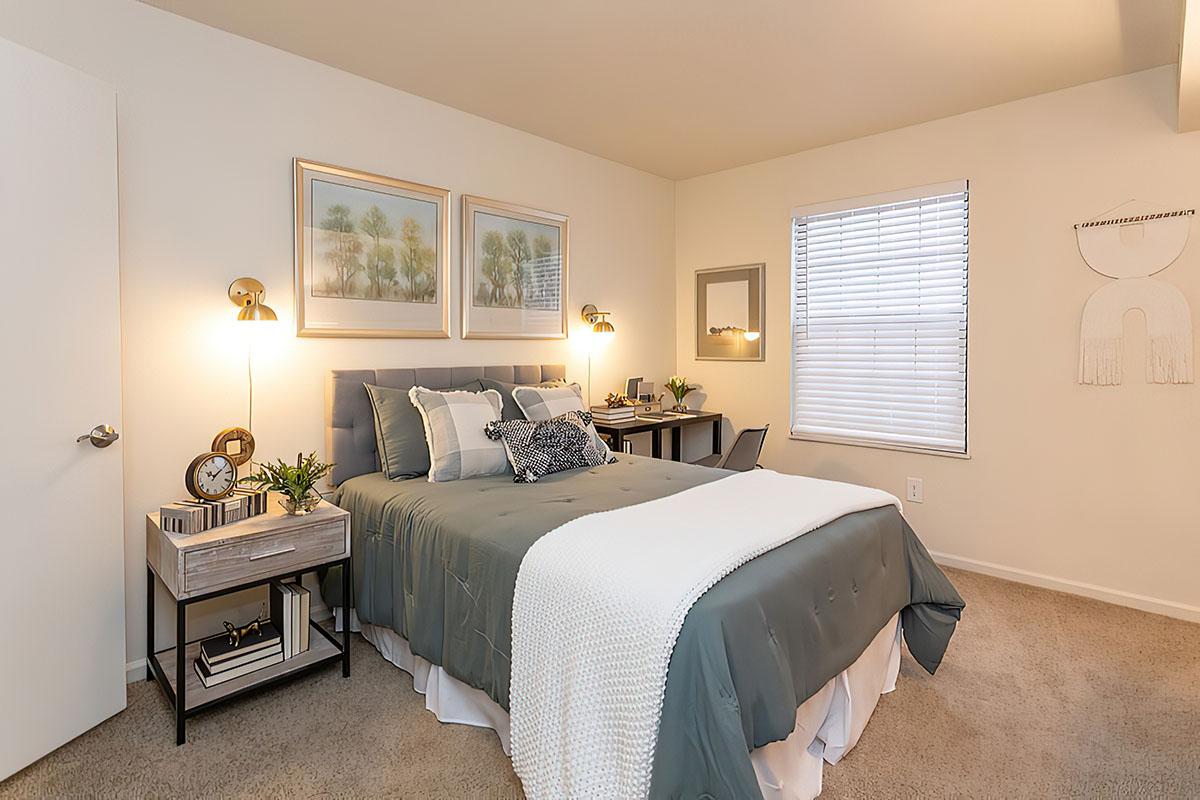 a bedroom with a bed and desk in a hotel room