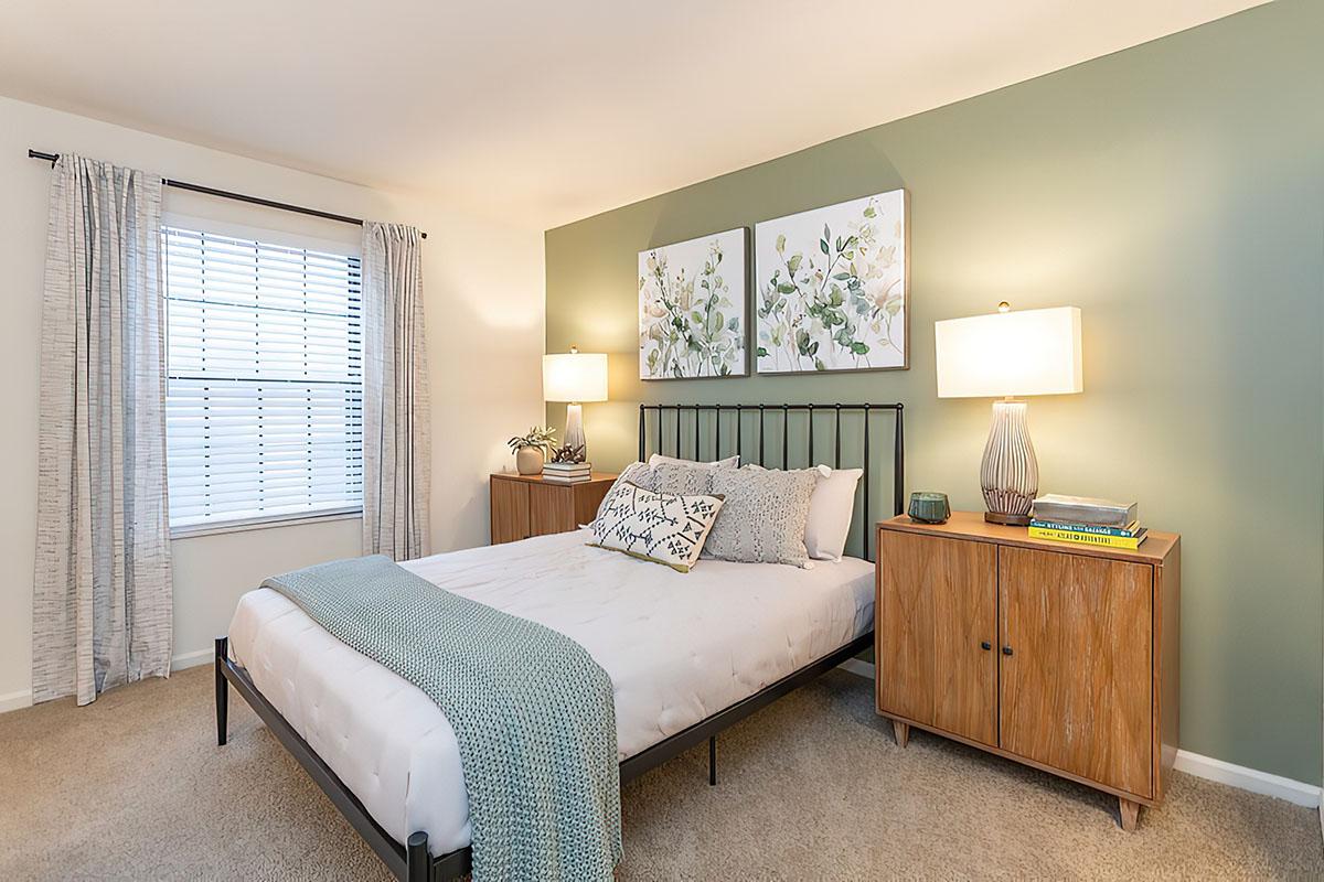 a bedroom with a bed and desk in a hotel room