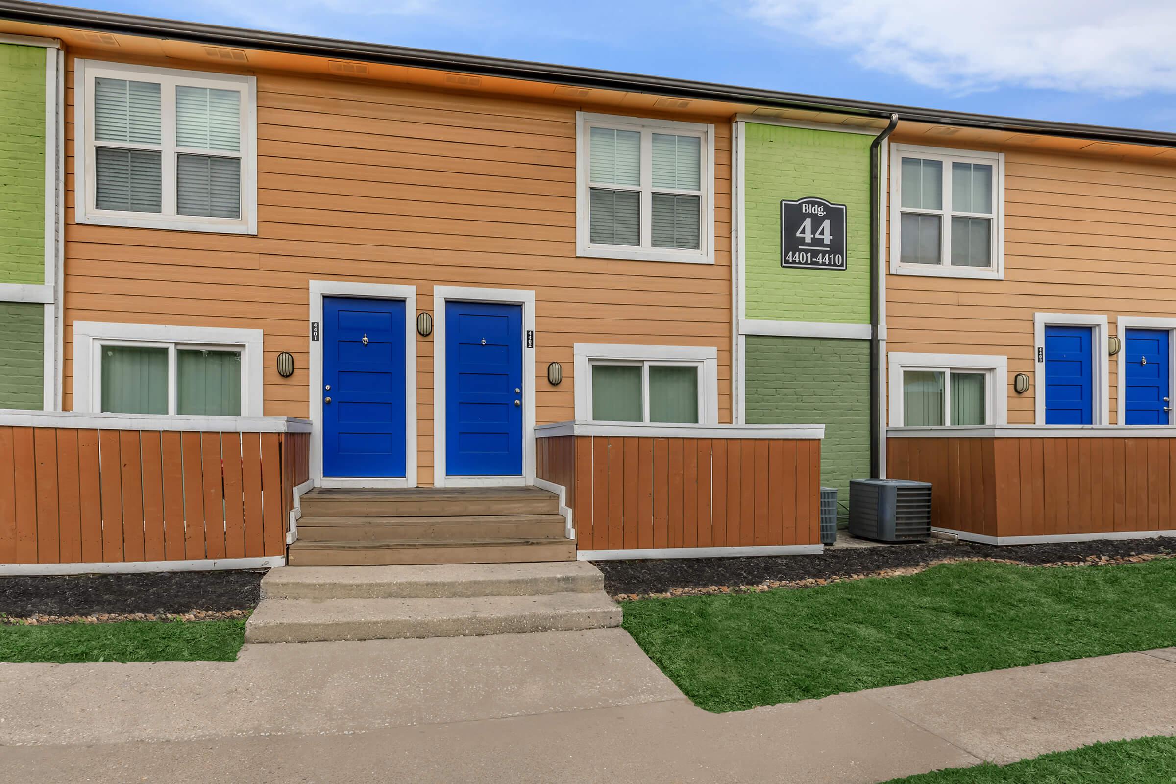 a close up of a brick building with grass in front of a house