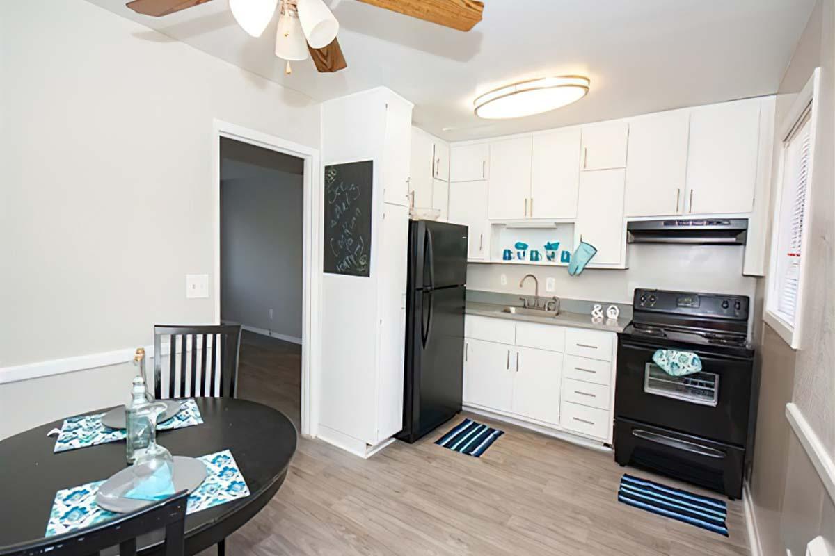 a living room filled with furniture and a stove in a kitchen