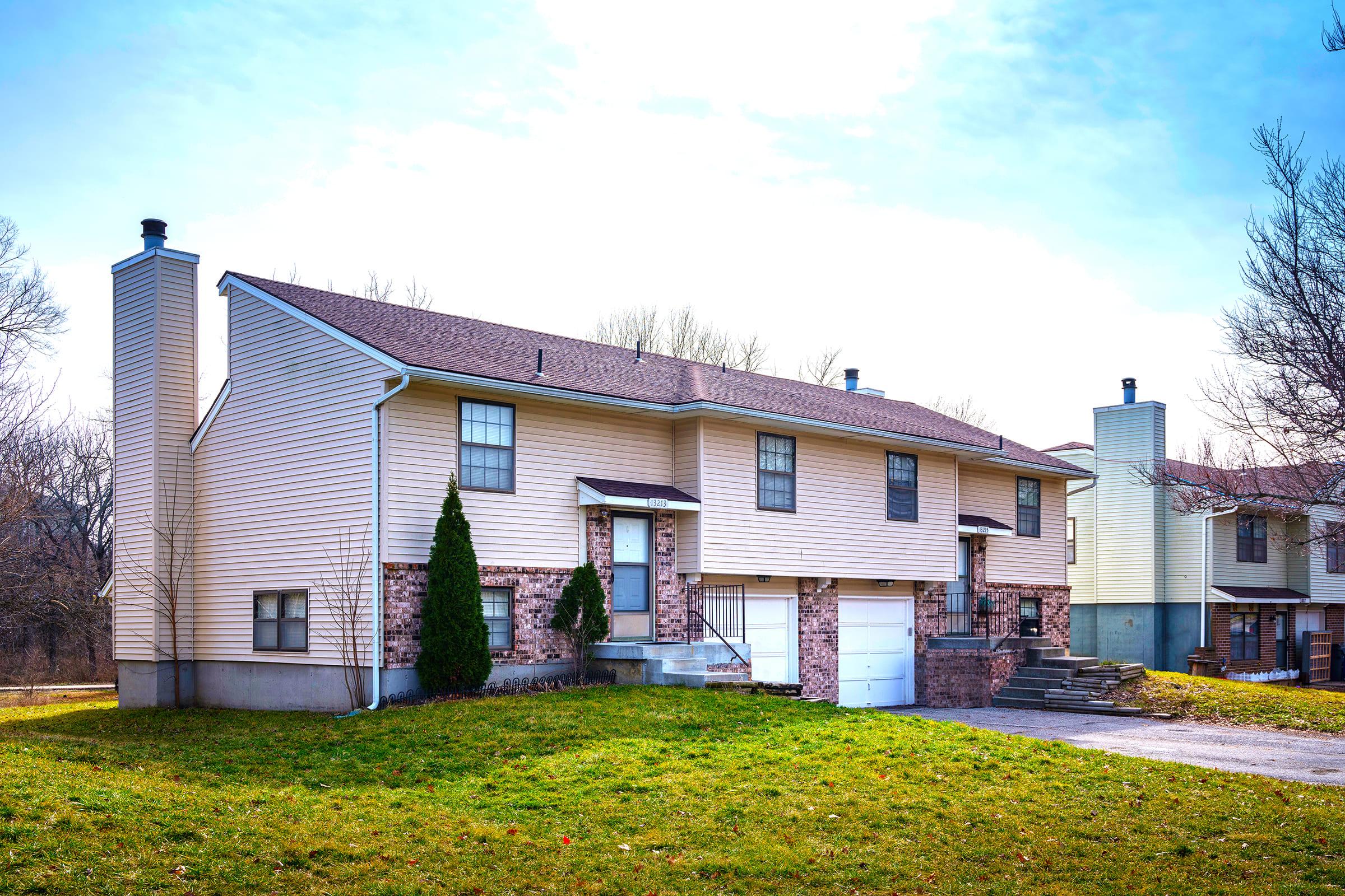 a large brick building with grass in front of a house