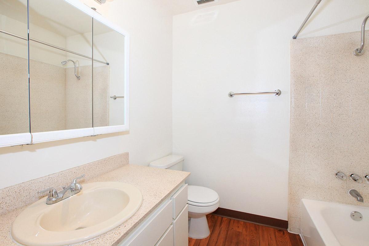 a white sink sitting under a mirror