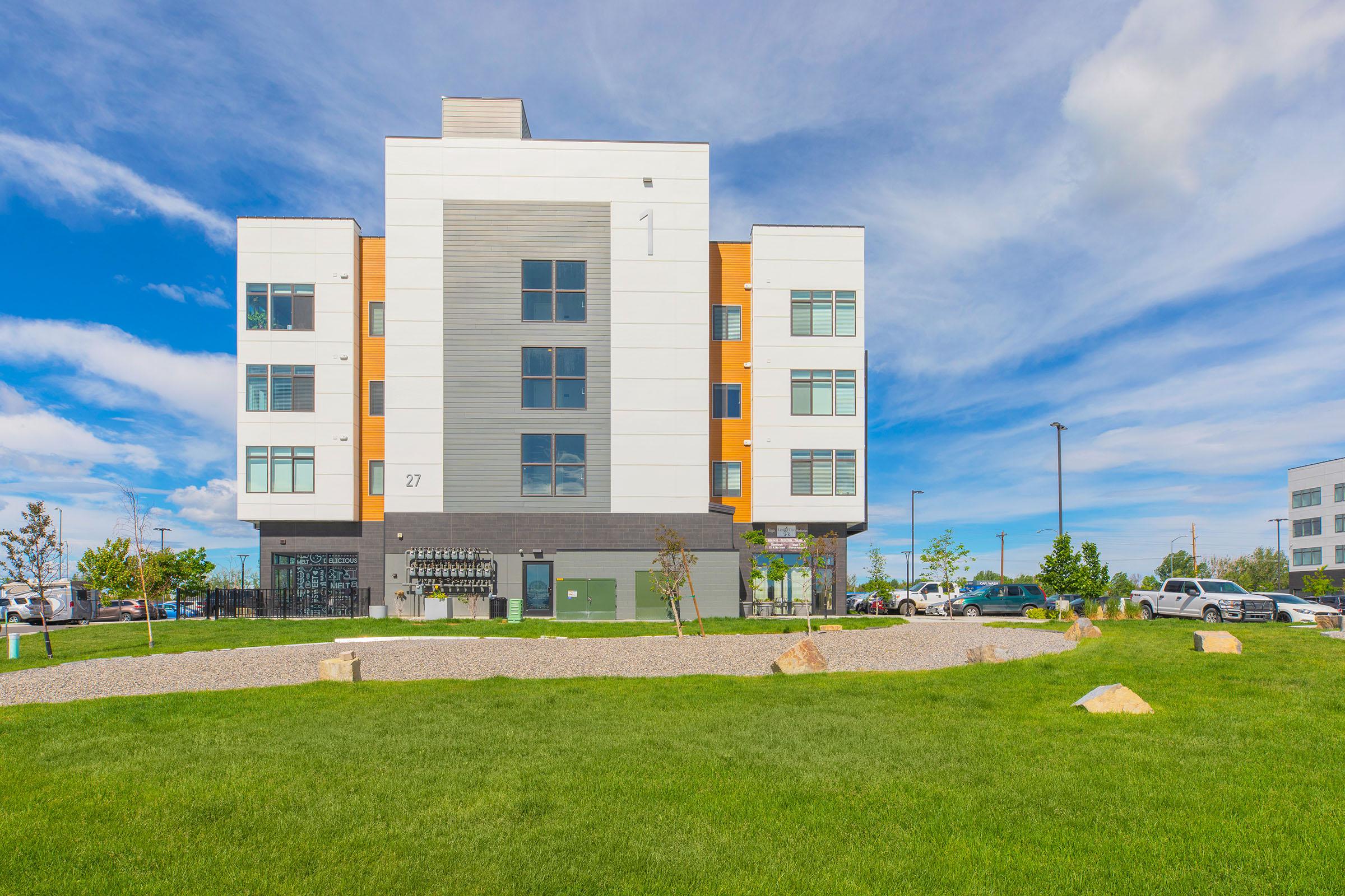 a large building with a green field