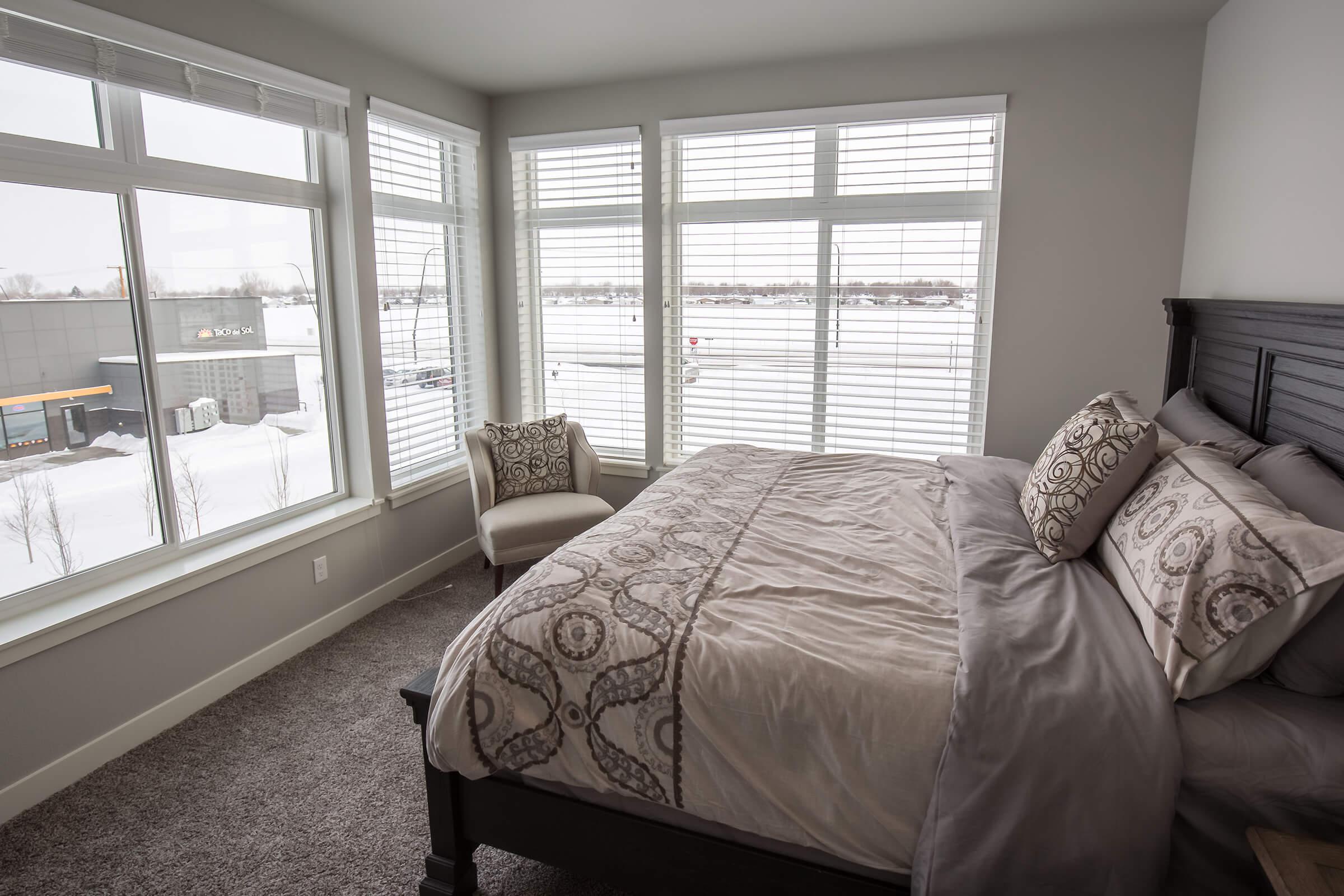 a bedroom with a bed and a large window