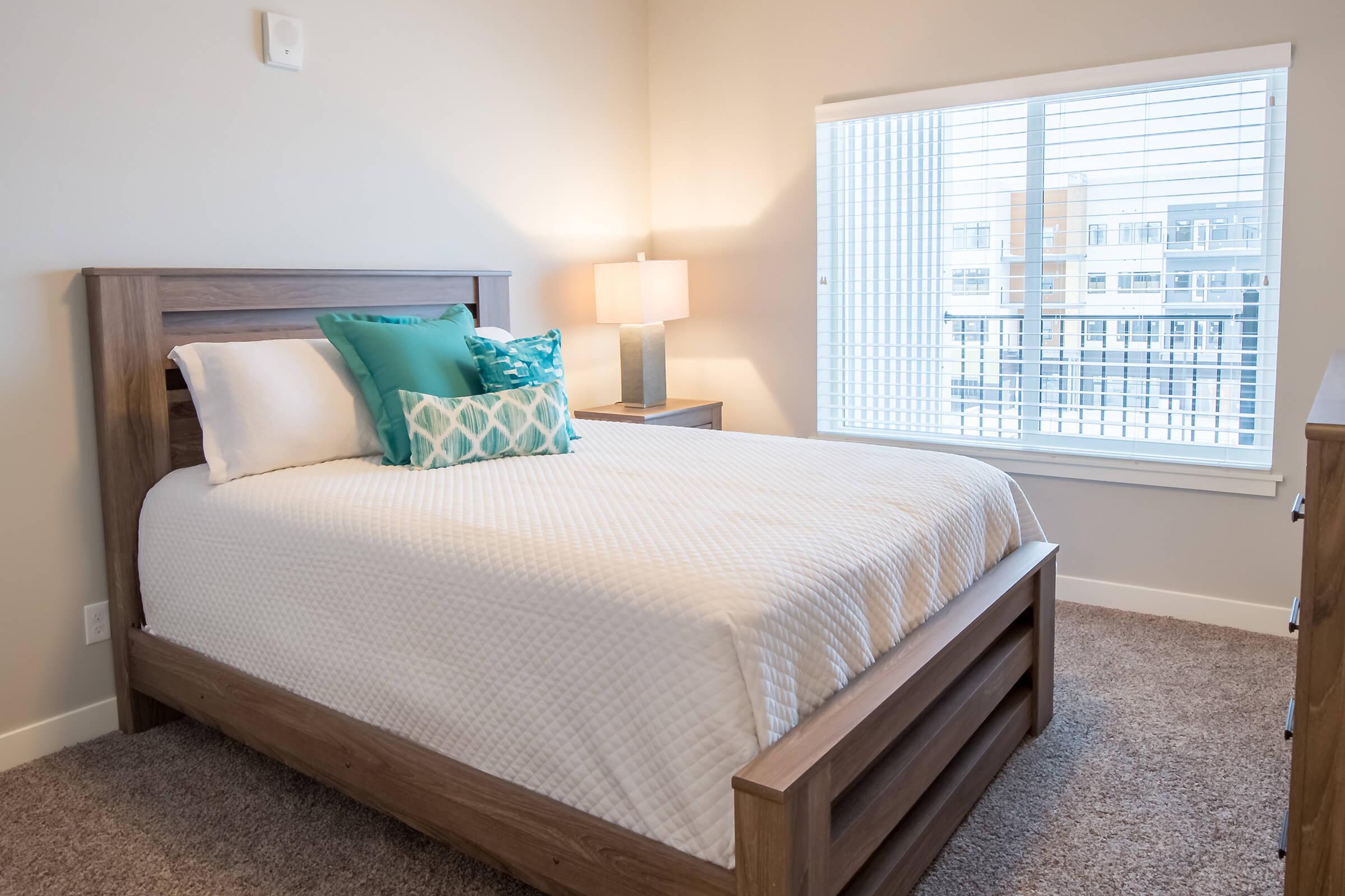 a bedroom with a bed and desk in a hotel room