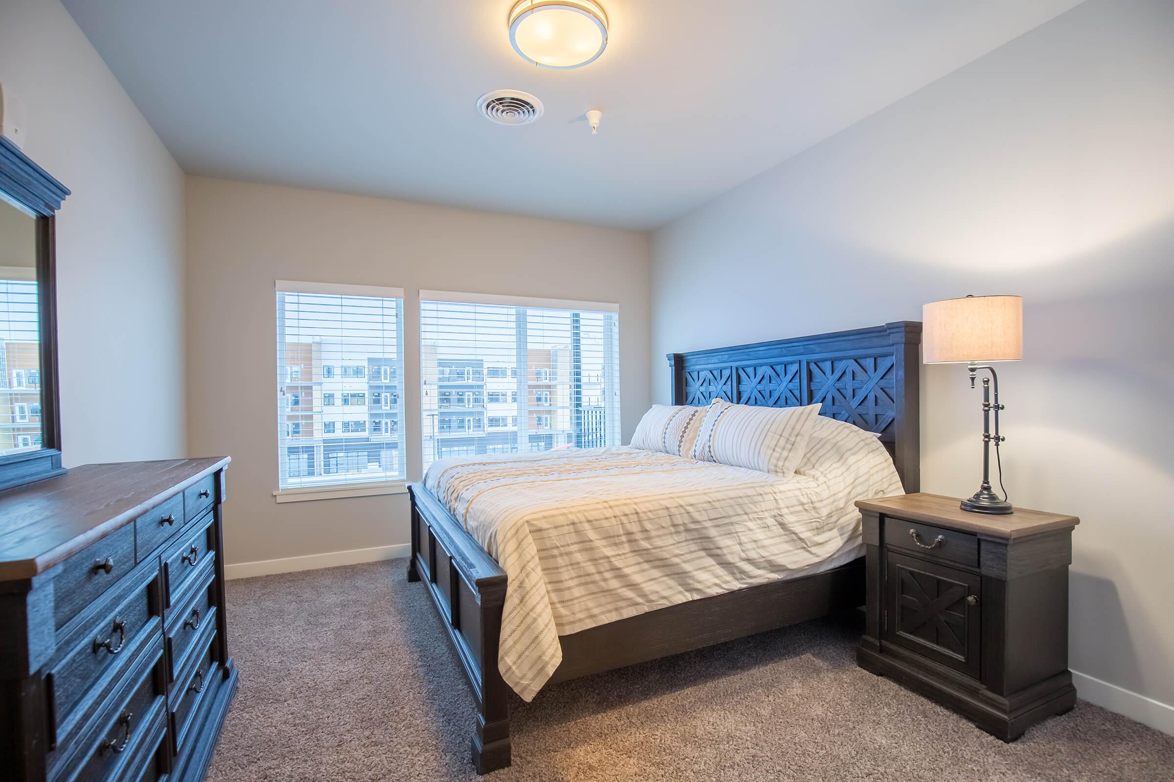 a bedroom with a bed and desk in a room