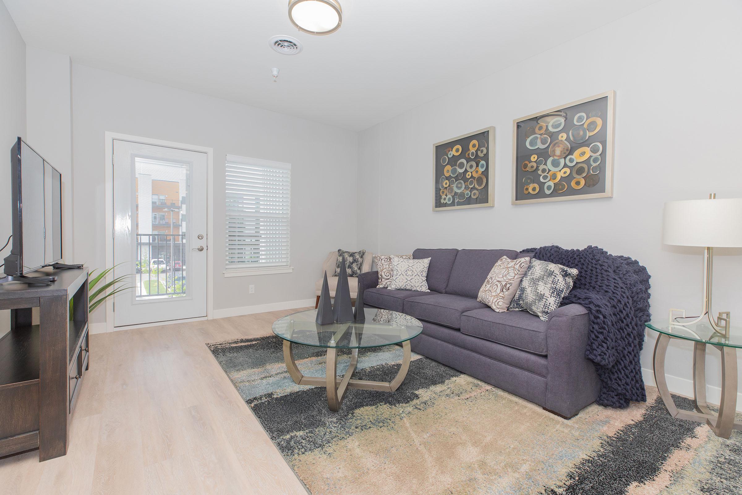 a living room filled with furniture and a large window