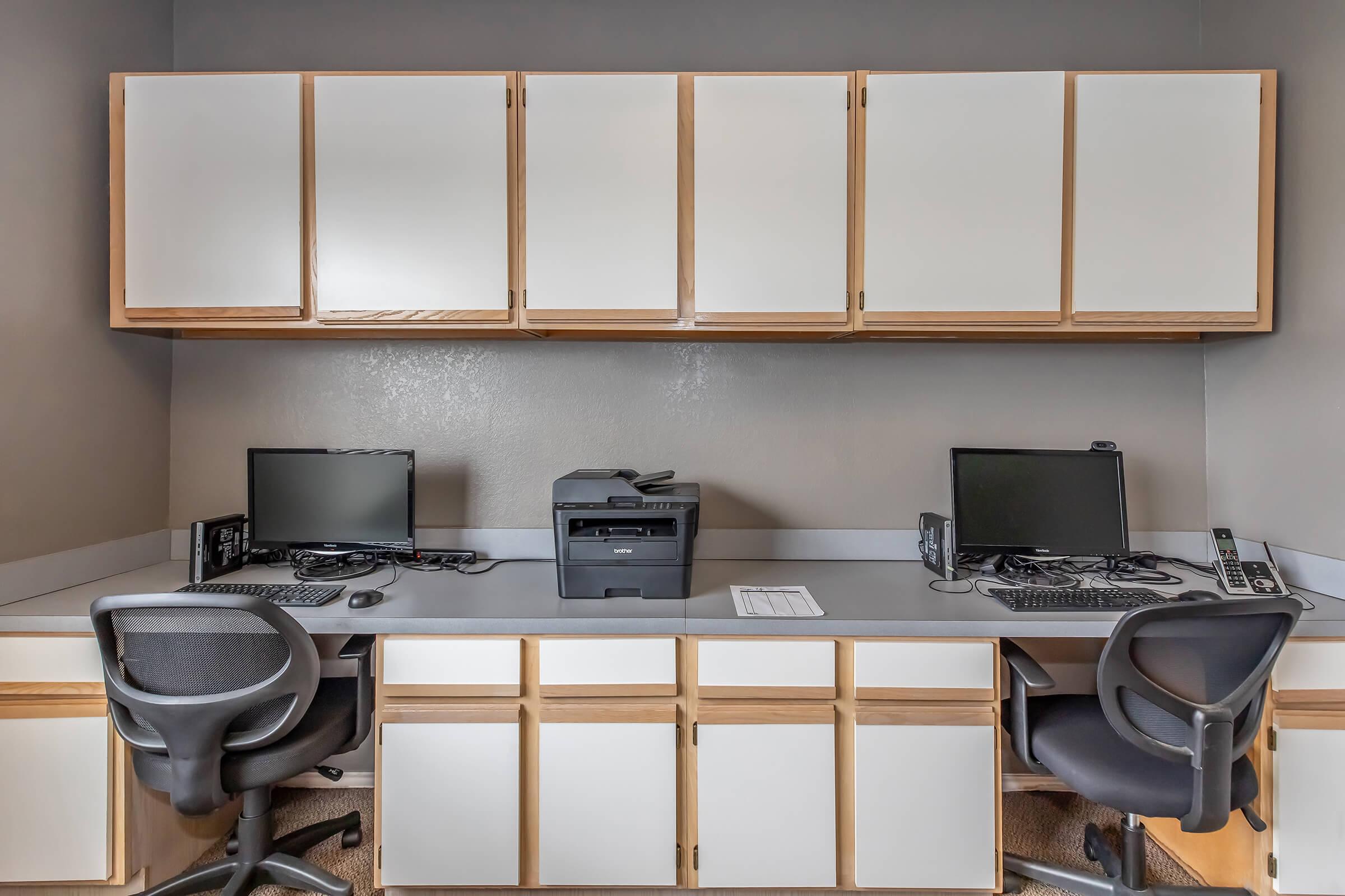 a desk with a computer and a chair in a room