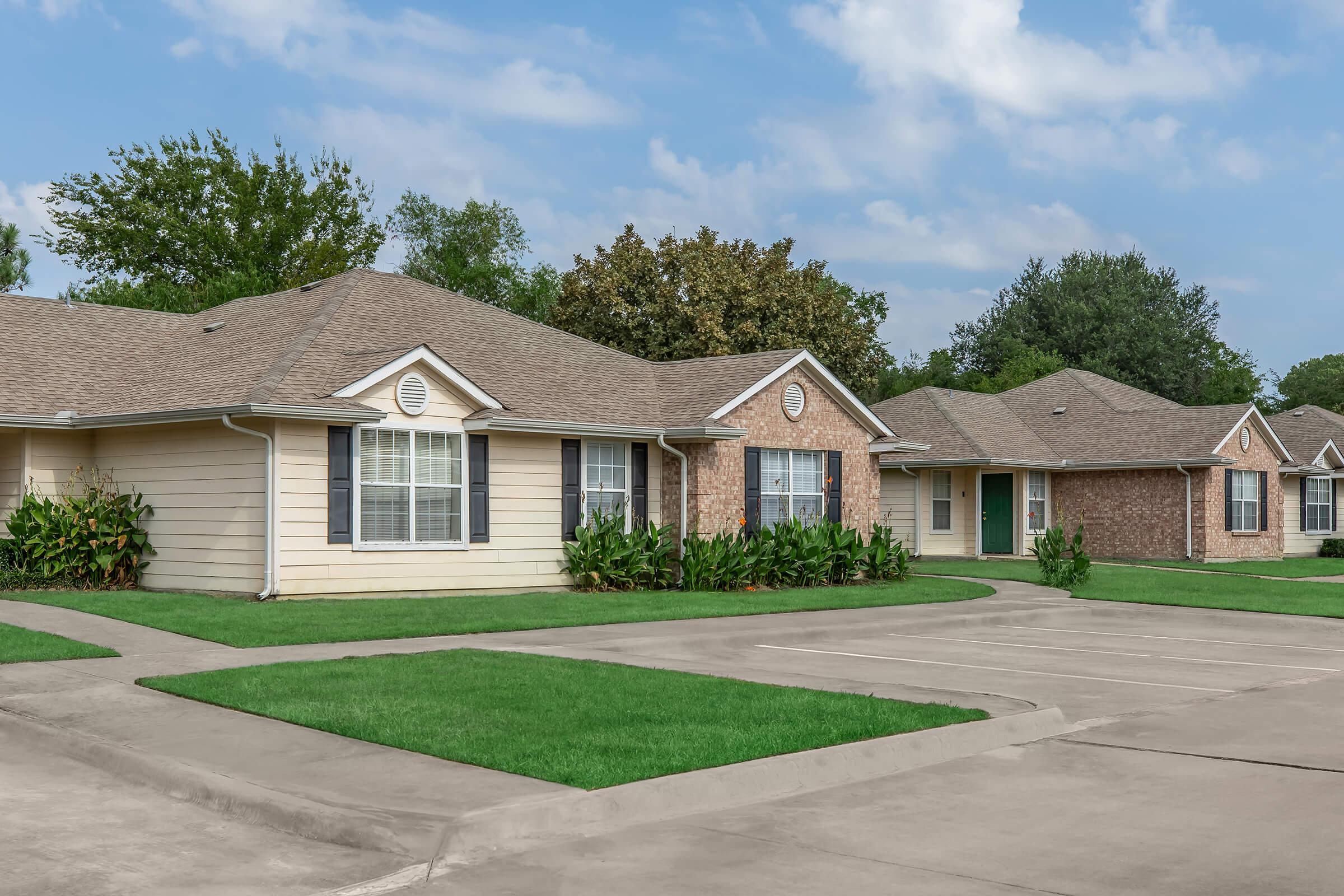 a large brick building with grass in front of a house