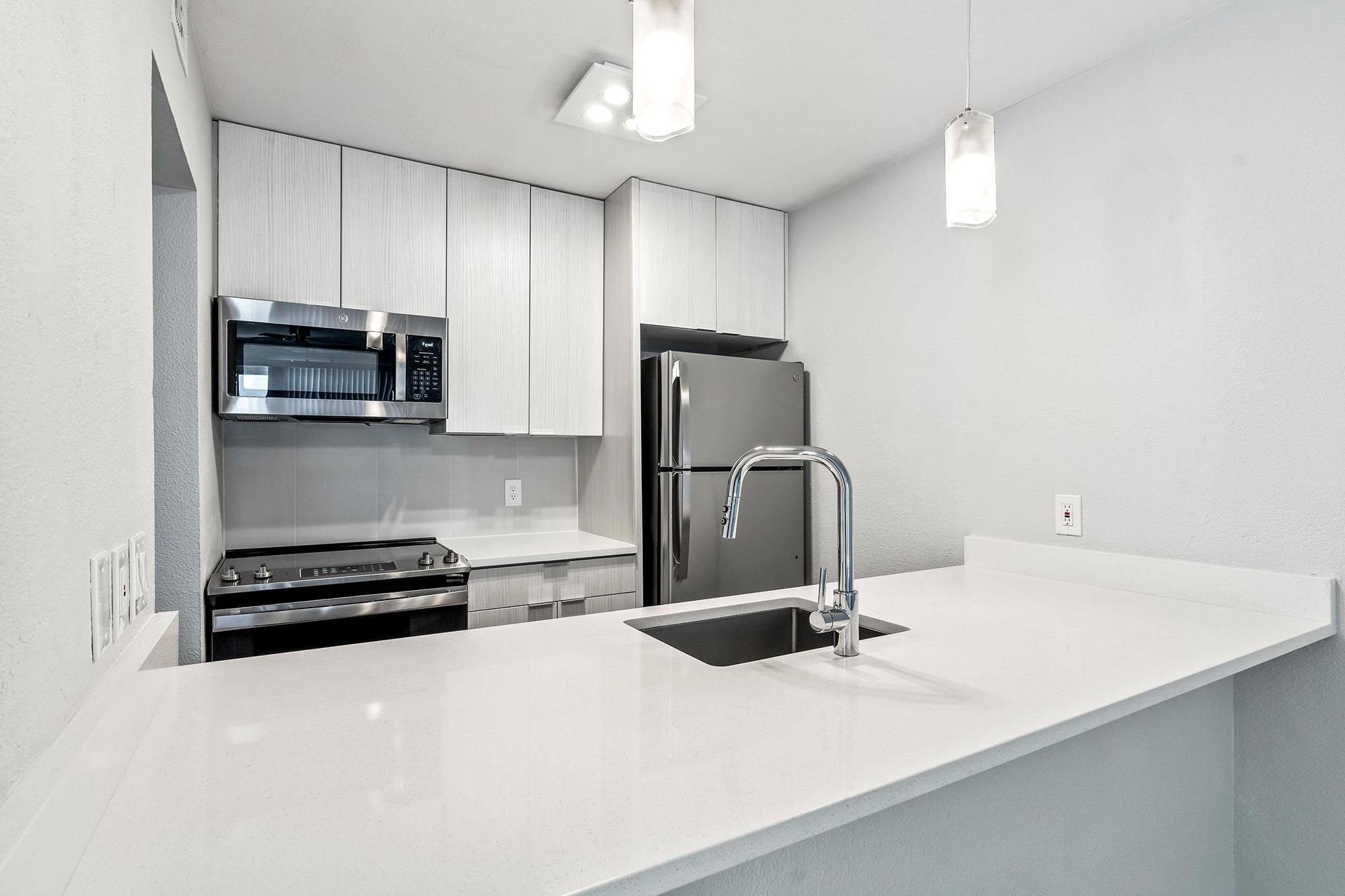 a kitchen with a sink and a mirror