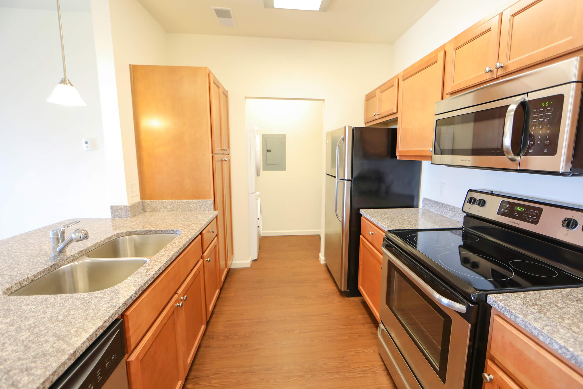 a large kitchen with stainless steel appliances and wooden cabinets