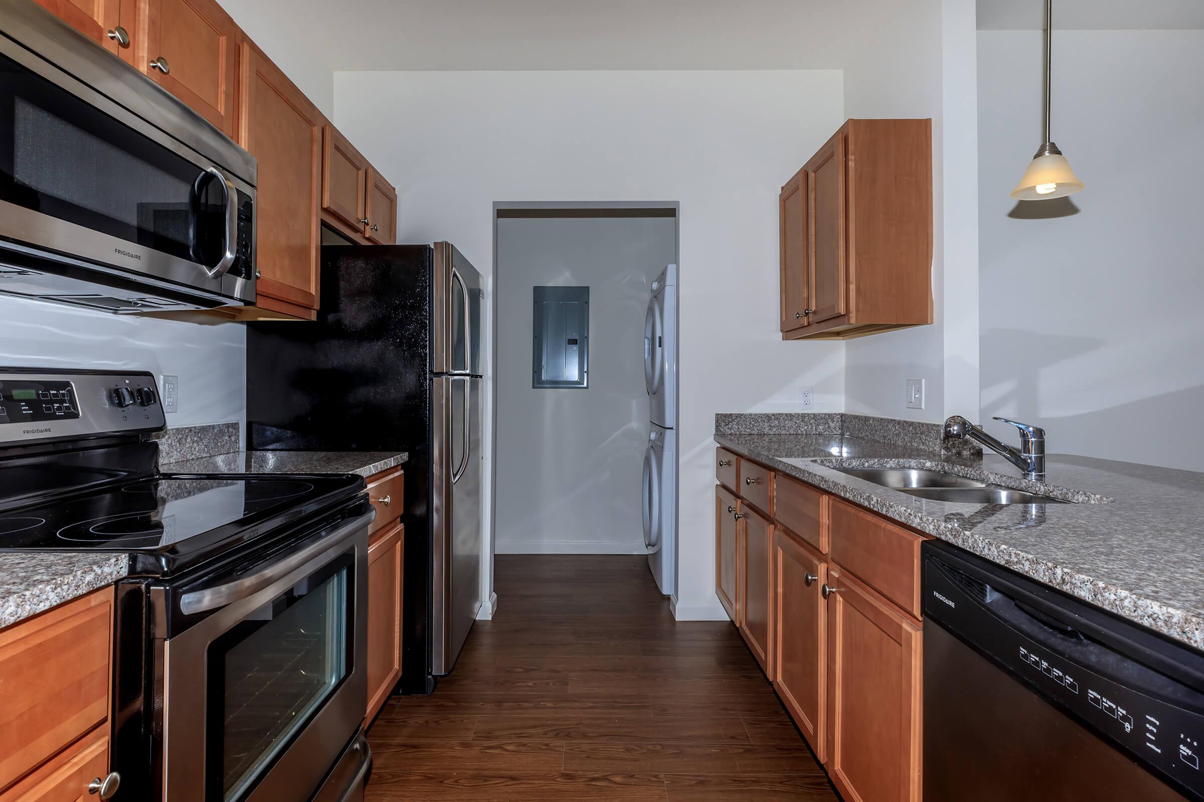 a large kitchen with stainless steel appliances and wooden cabinets