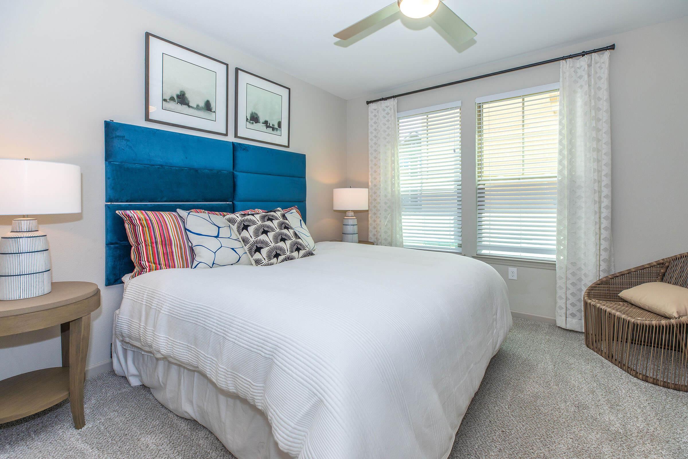 a bedroom with a bed and desk in a hotel room