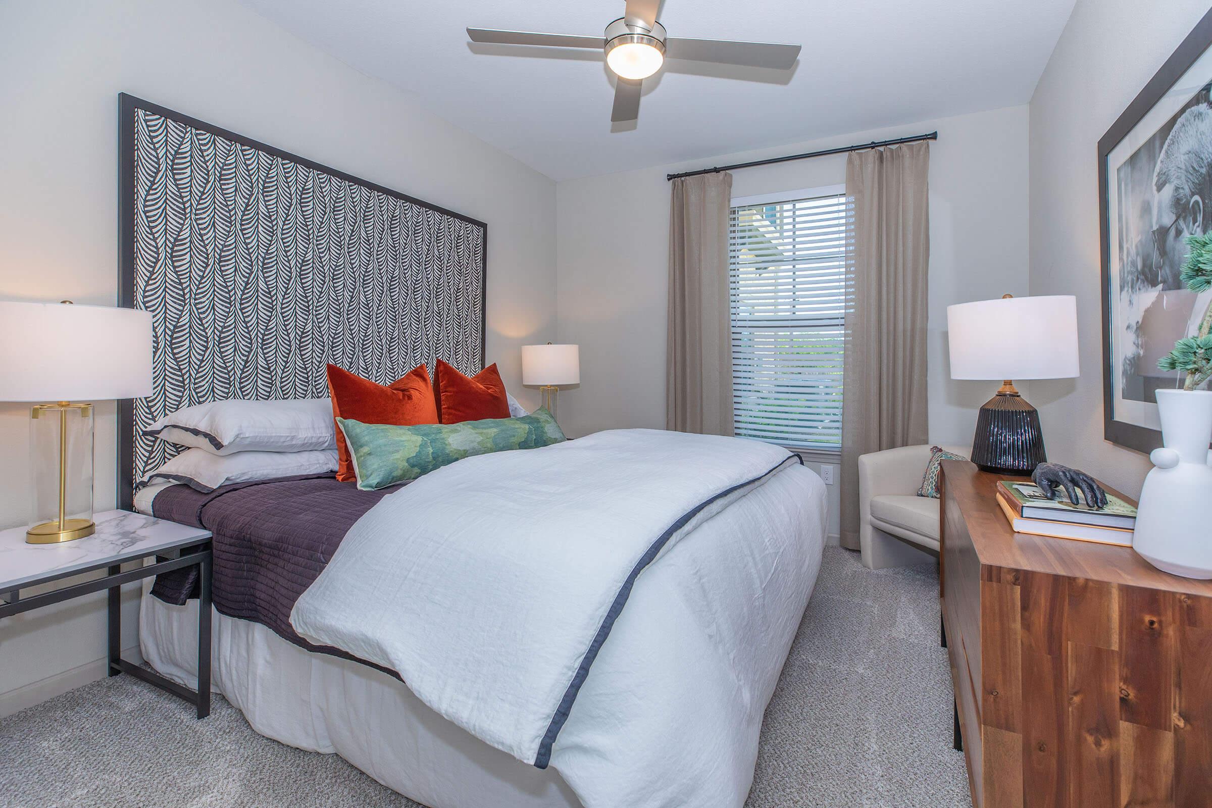 a bedroom with a bed and desk in a room