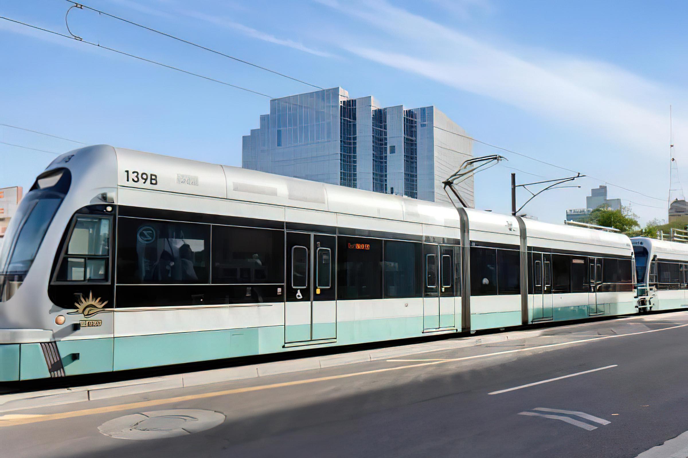 a passenger train stopped at a bus stop