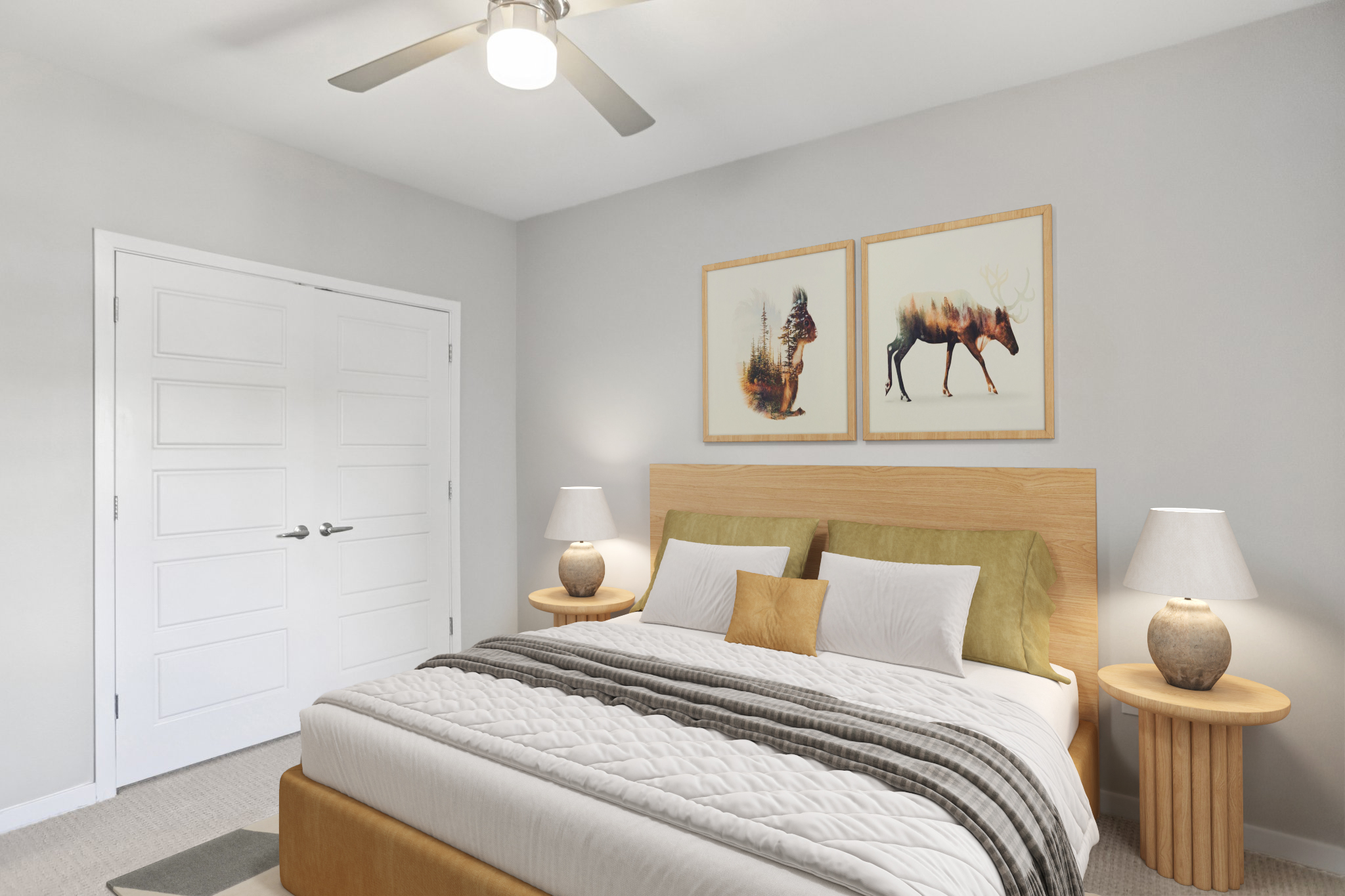 A cozy bedroom featuring a large bed with green and white bedding, flanked by two round wooden nightstands with lamps. The walls are light gray, and there are two framed animal art pieces above the bed. A ceiling fan hangs above, and a closet is visible in the background.