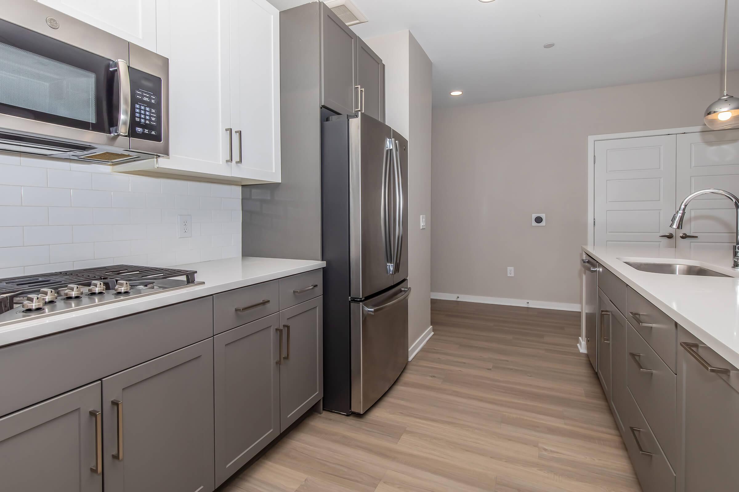 a large kitchen with stainless steel appliances and wooden cabinets