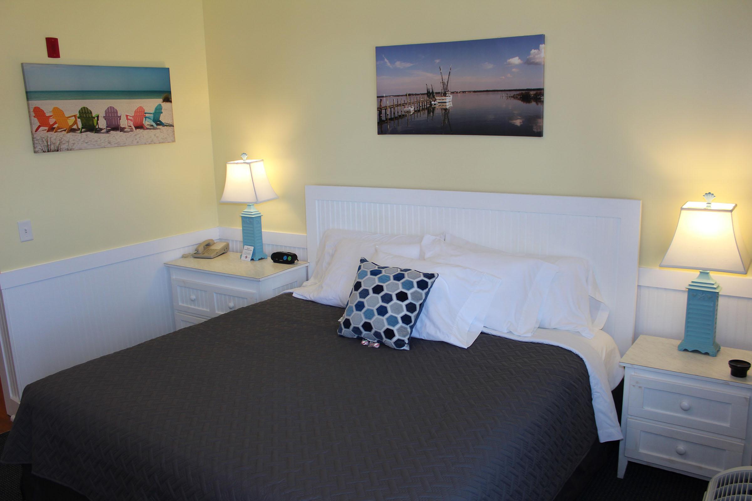 a bedroom with a bed and desk in a hotel room