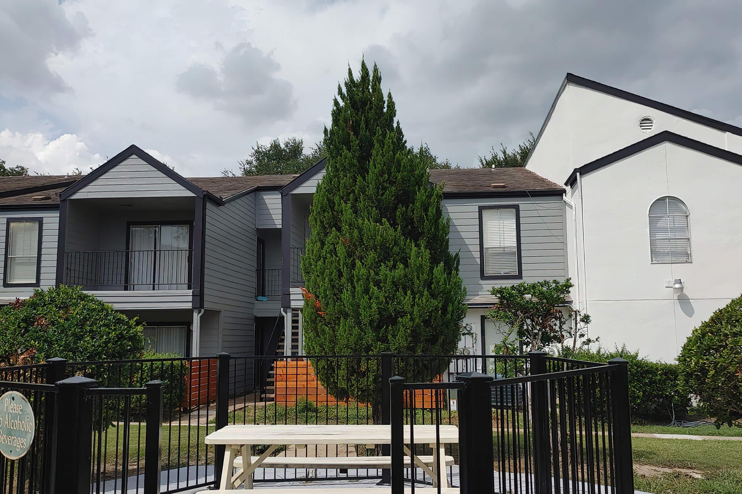 a house with a fence in front of a building