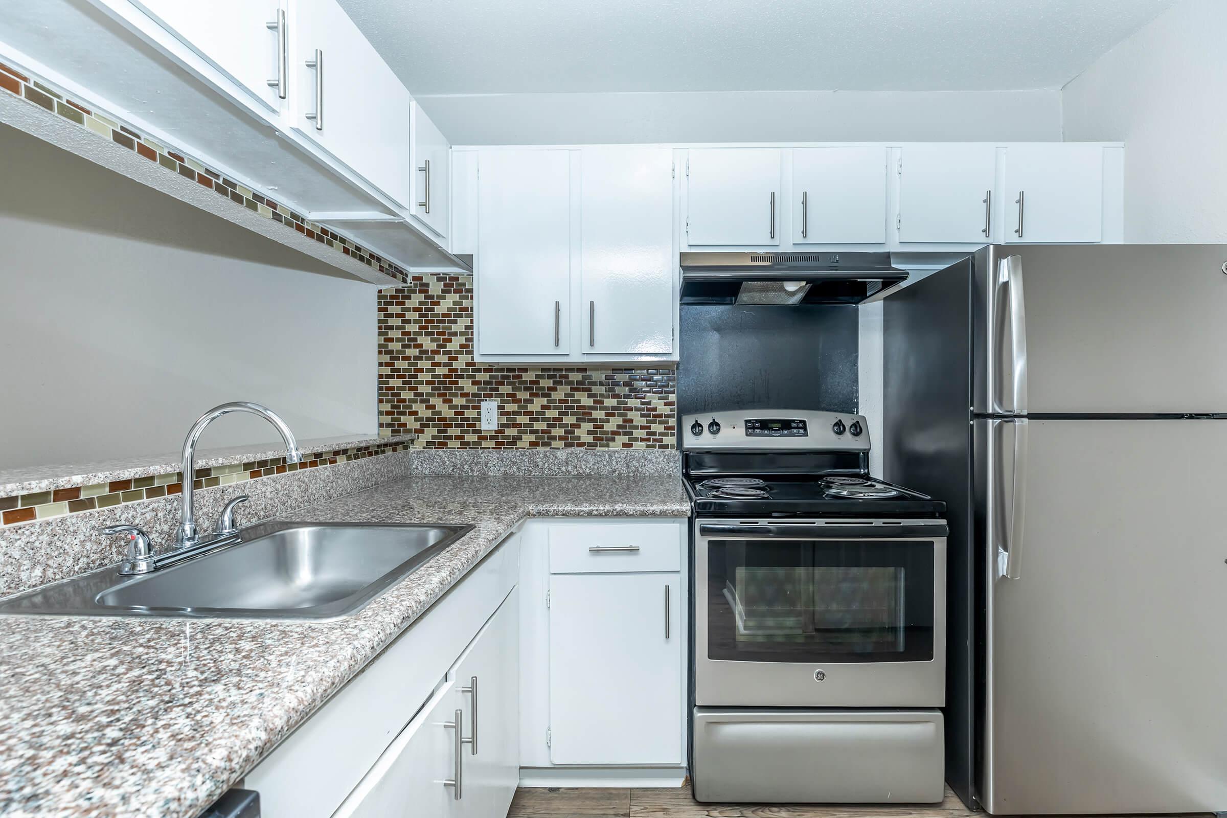 a stove top oven sitting inside of a kitchen