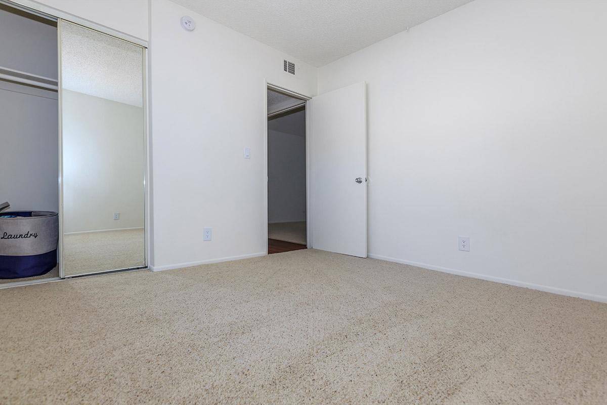 Bedroom with open sliding mirror glass closet door