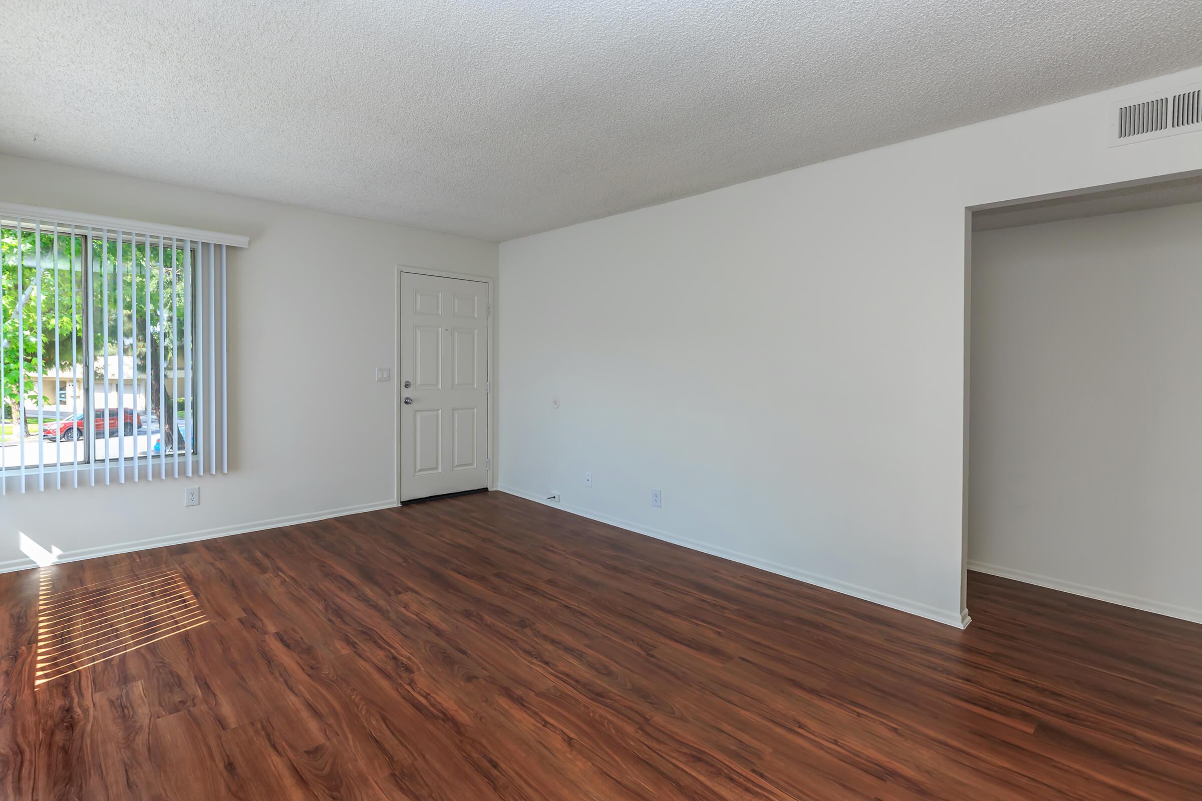 Unfurnished living room with wooden floors