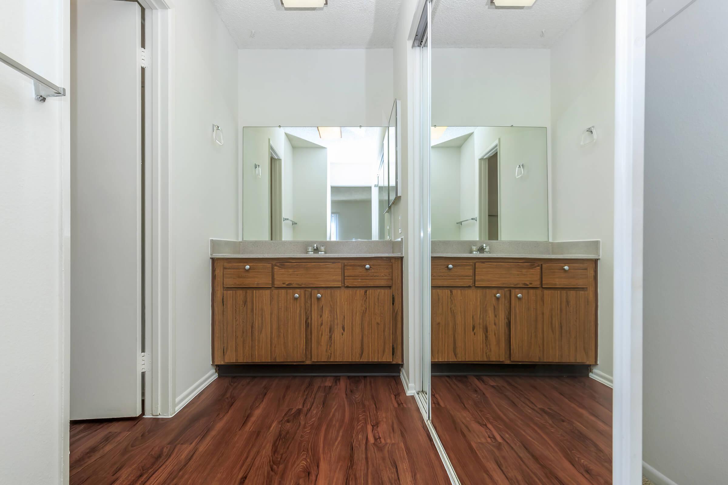 Bathroom sink and open sliding mirror glass closet door