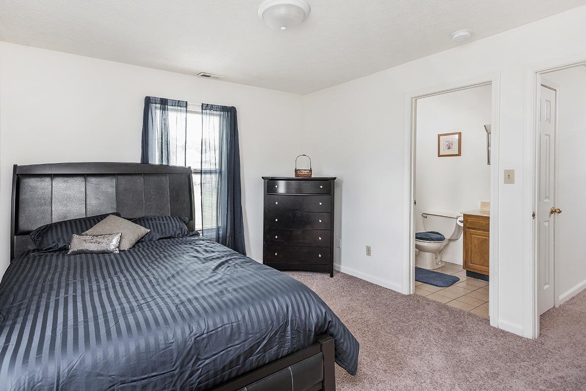 a bedroom with a bed and desk in a room