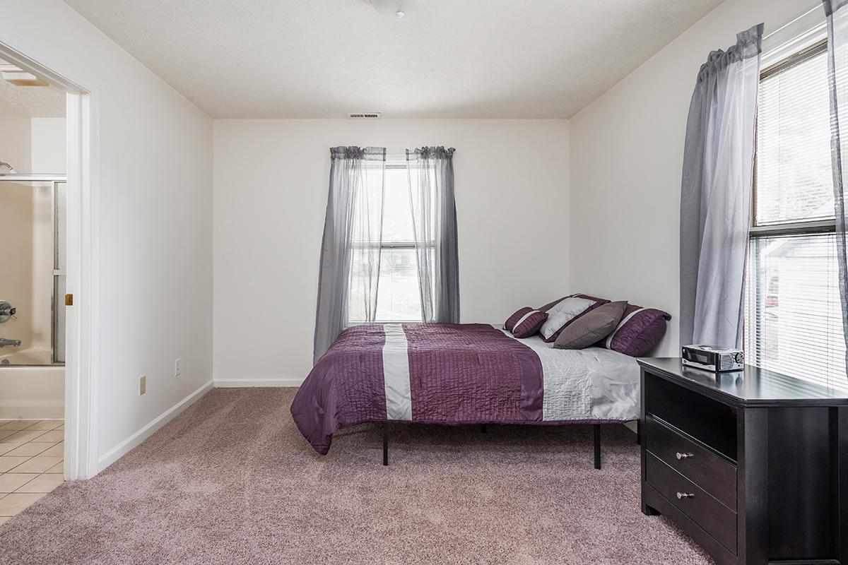 a bedroom with a bed and desk in a room