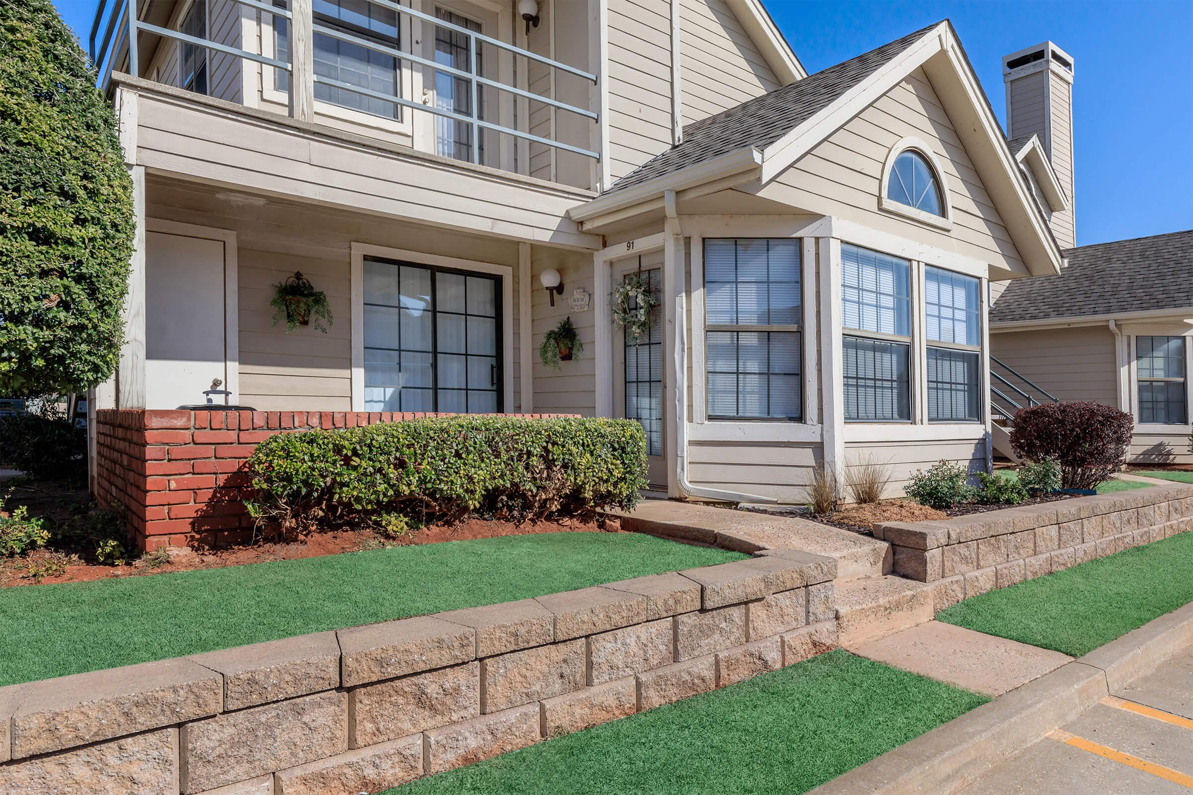 a stone building that has a bench in front of a house