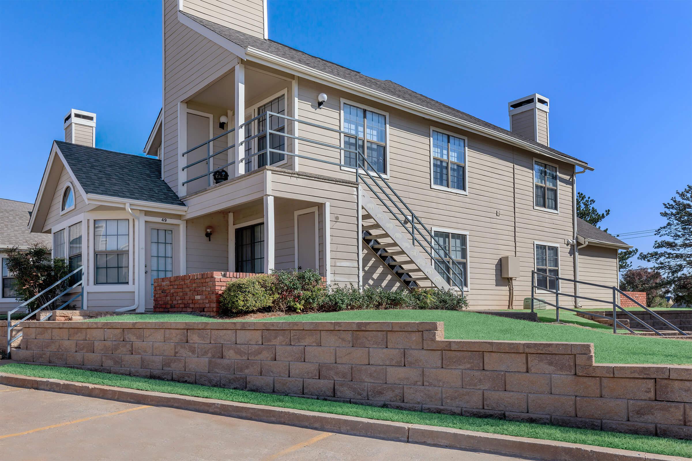 a large brick building with grass in front of a house