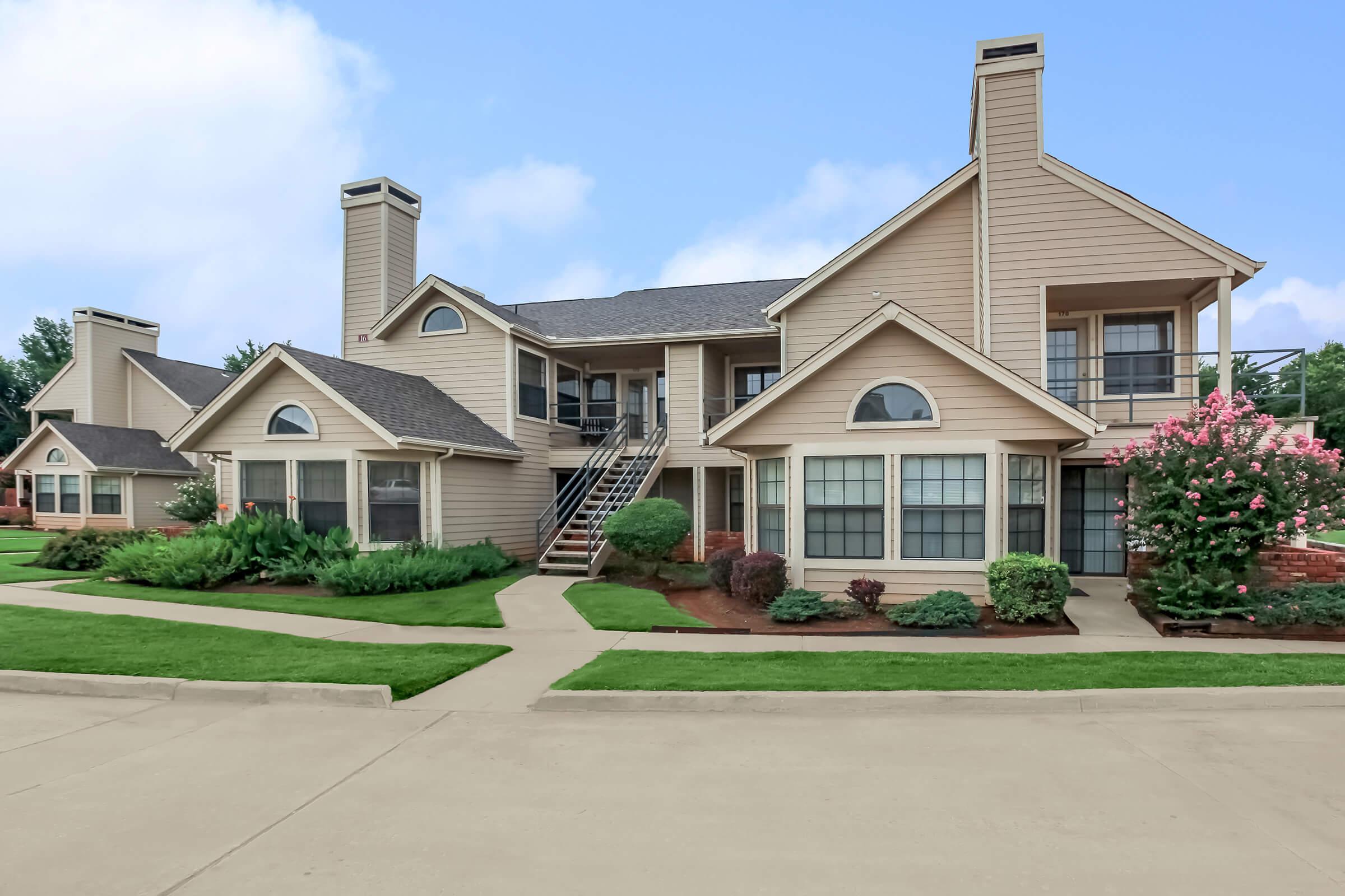 a large brick building with grass in front of a house