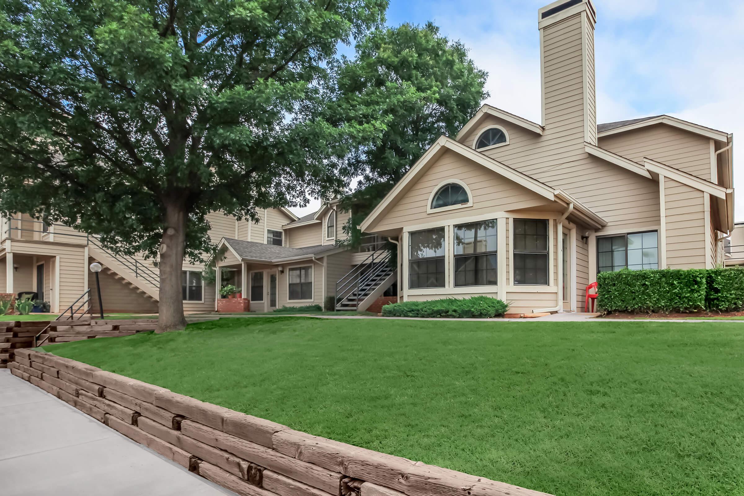 a large brick building with grass in front of a house