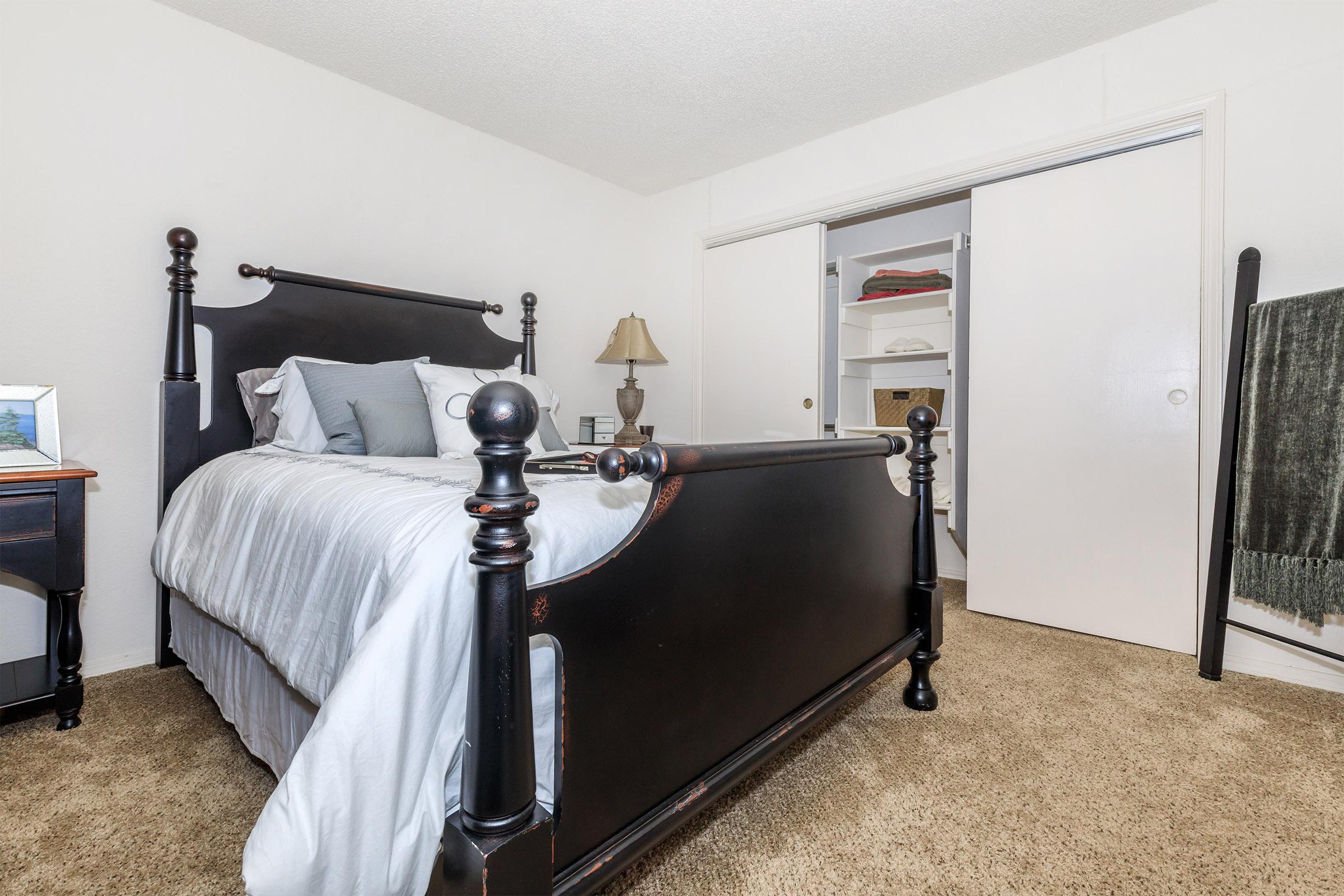 a bedroom with a bed and desk in a room