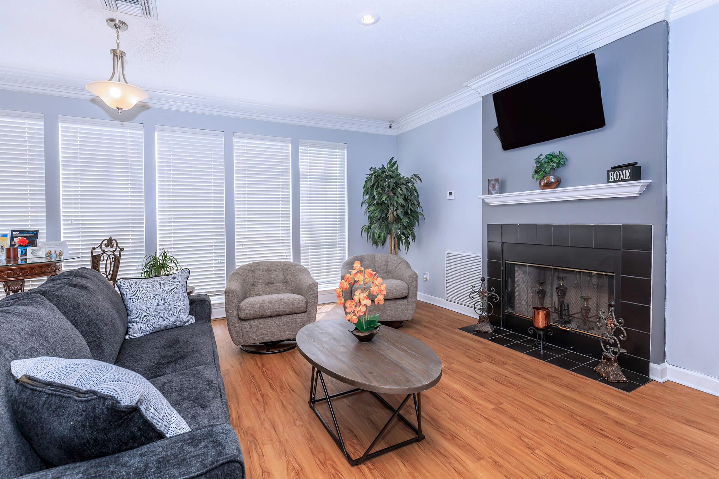 a living room filled with furniture and vase of flowers on a table