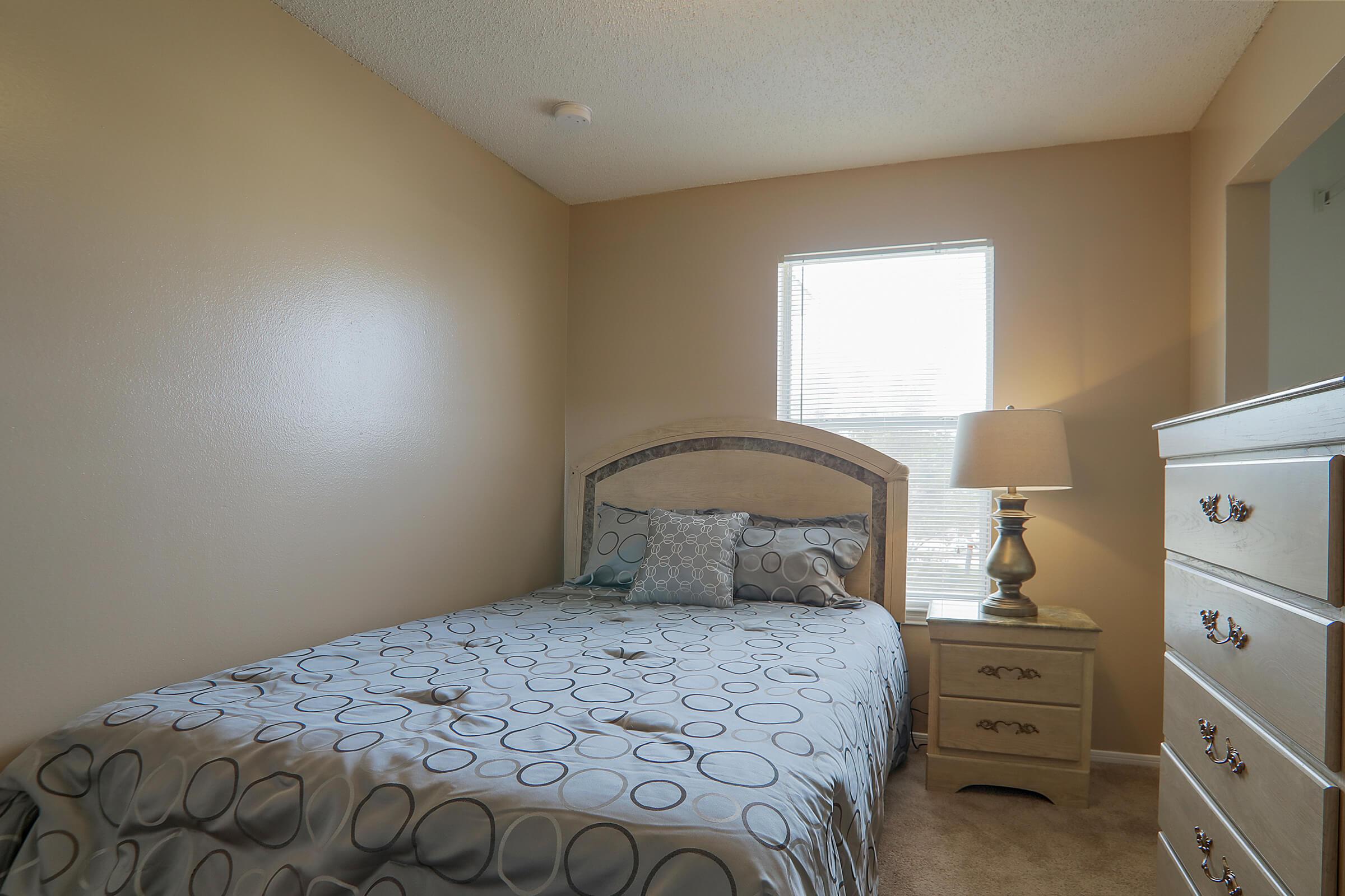 a bedroom with a bed and desk in a small room