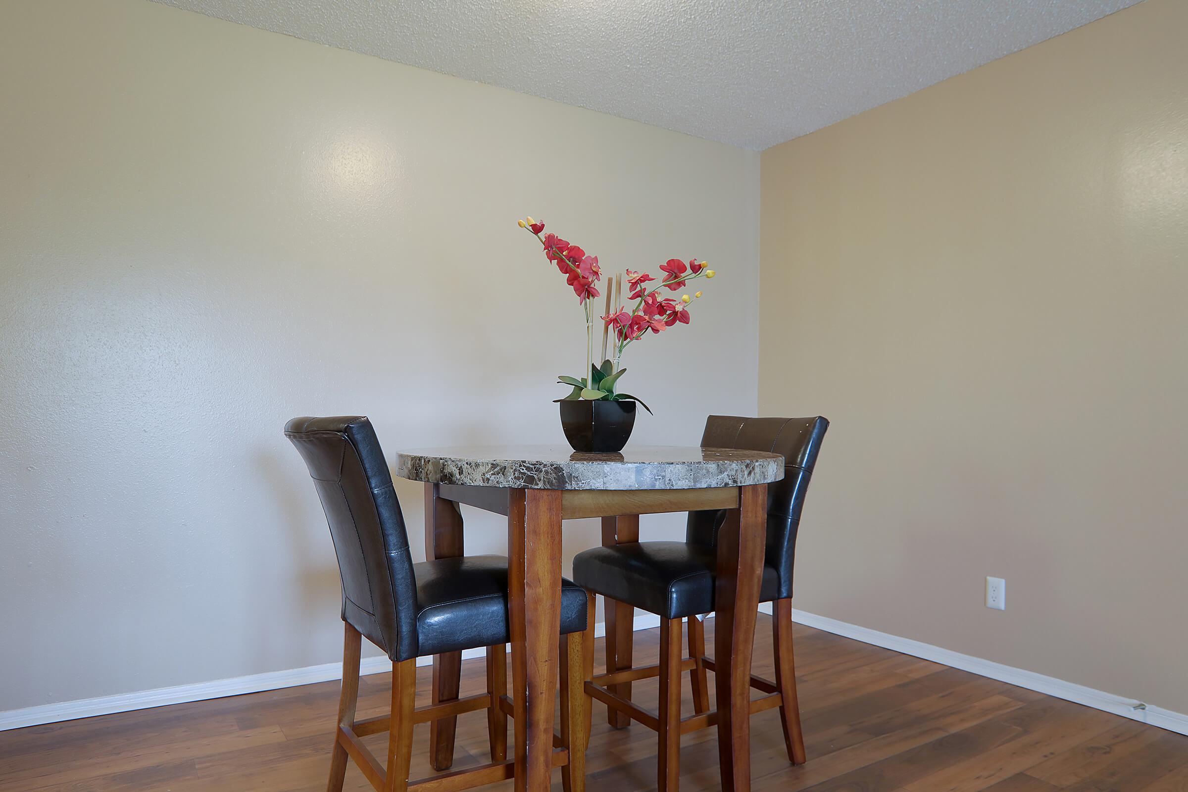 a living room filled with furniture and vase of flowers on a table