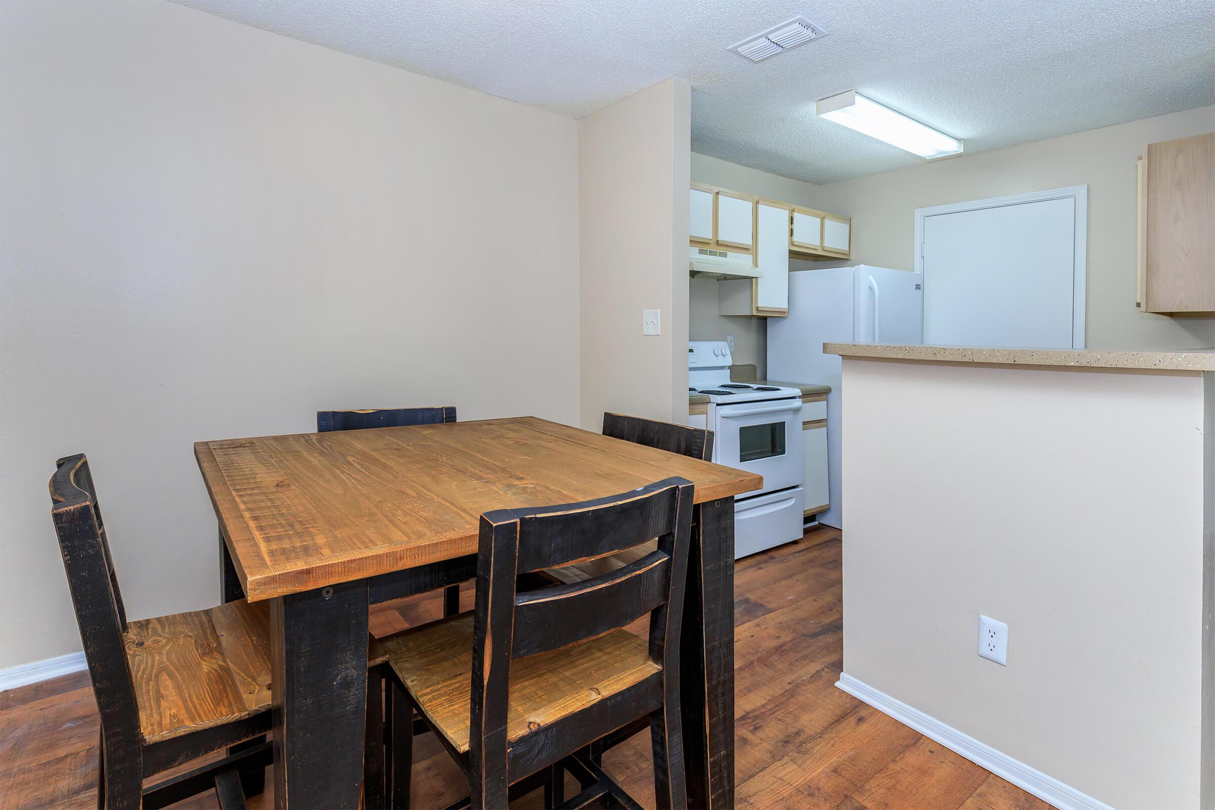 a kitchen with wooden cabinets and a dining room table