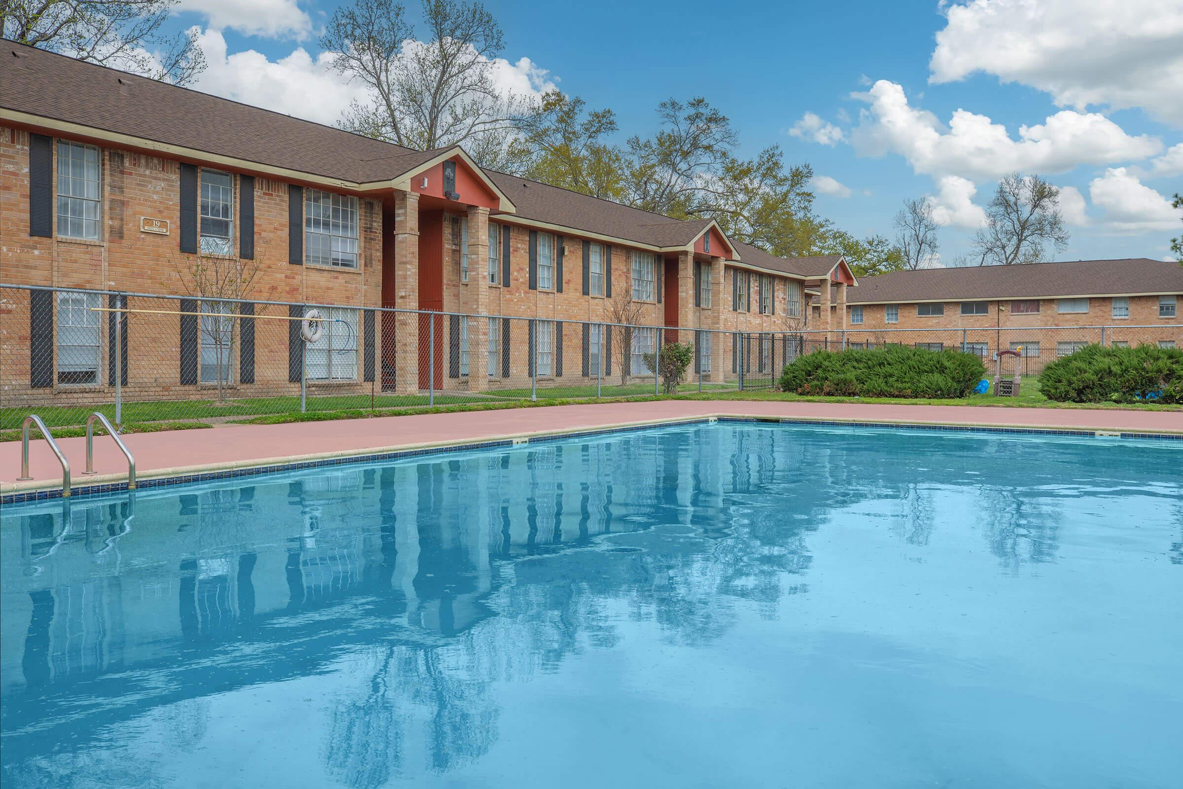 a large brick building with a pool of water