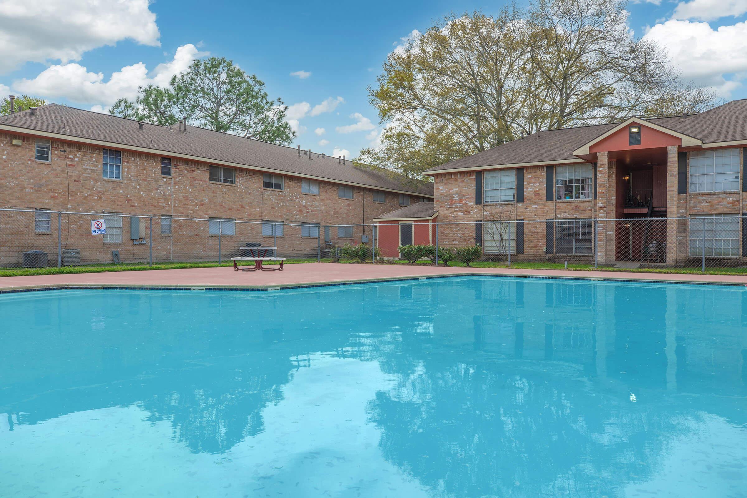 a large brick building with a pool of water