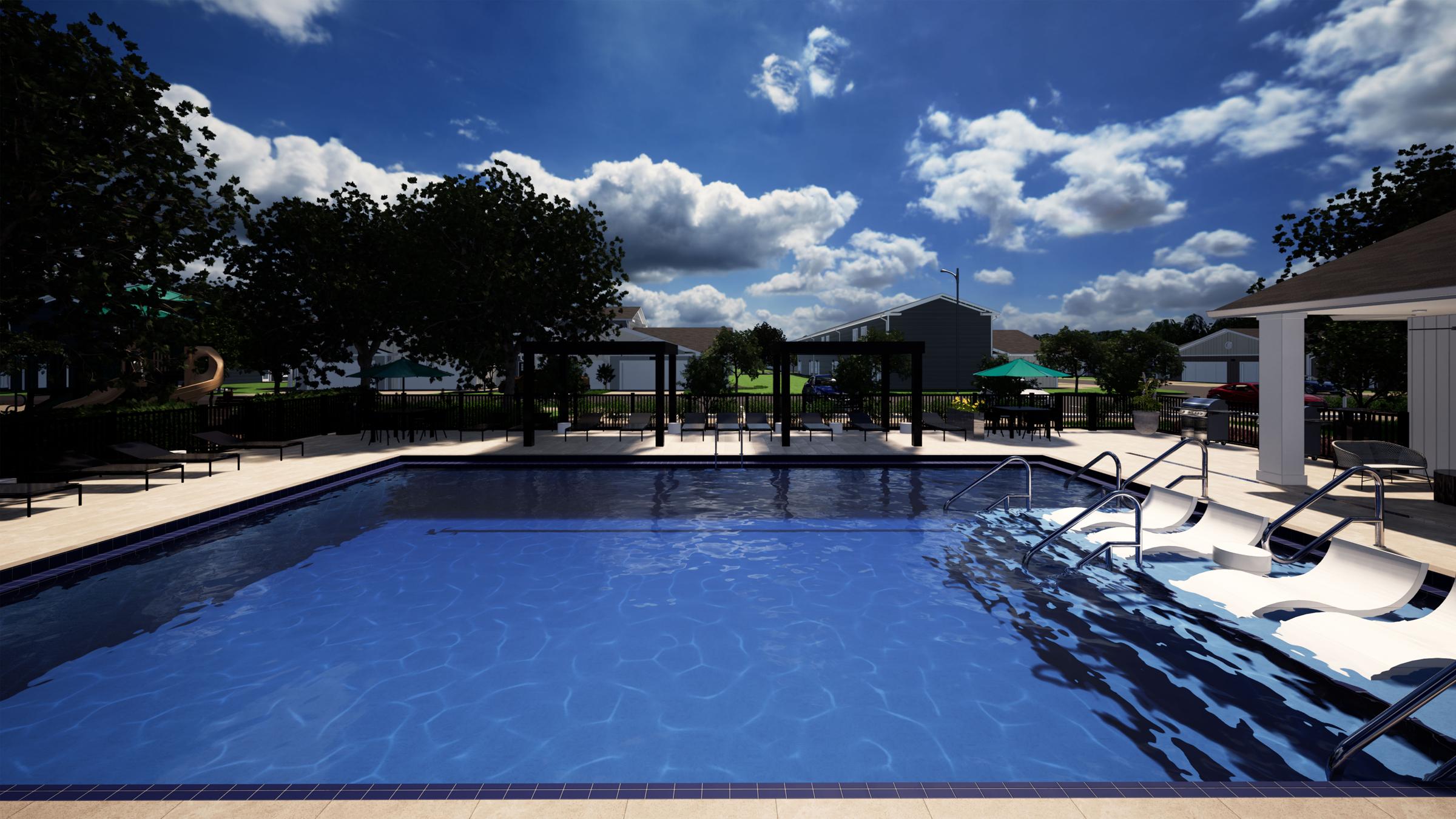 A bright outdoor swimming pool surrounded by lounge chairs and shaded areas. Trees are visible in the background, with blue skies and fluffy clouds overhead. The pool features a gradual entry with steps on one side, creating an inviting atmosphere for relaxation and leisure.